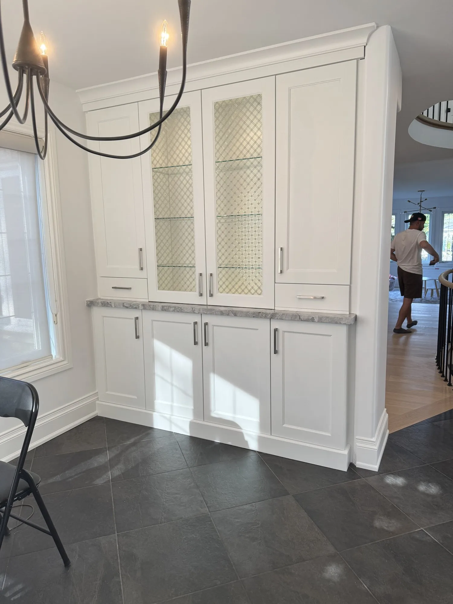 The finished built-in dresser run with glass-front uppers in Oxford White, the original granite top and slate floor unchanged
