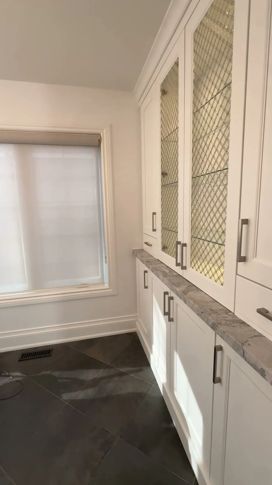 The finished Aurora Highlands kitchen — Oxford White perimeter cabinets around an Onyx island, the granite counters, mosaic backsplash and slate floor all unchanged