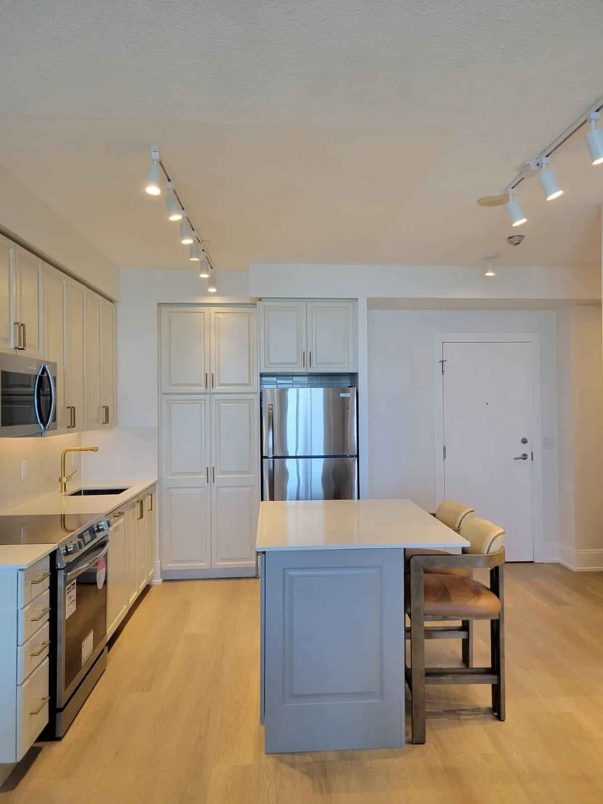 After — espresso repainted cream, island extended and finished in a second colour in City Centre, Mississauga