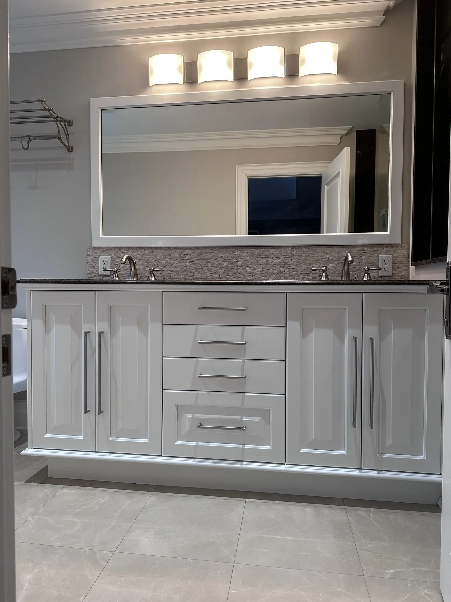 The finished vanity sprayed the same soft off-white as the kitchen cabinets, with the mirror and counter kept
