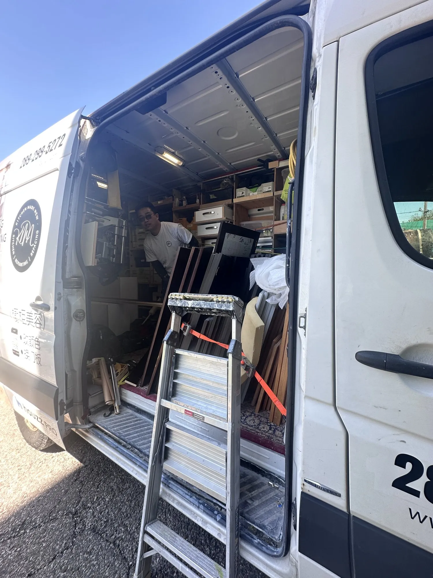 The van loaded with wrapped doors and panels standing on end, strapped for the drive back to the shop
