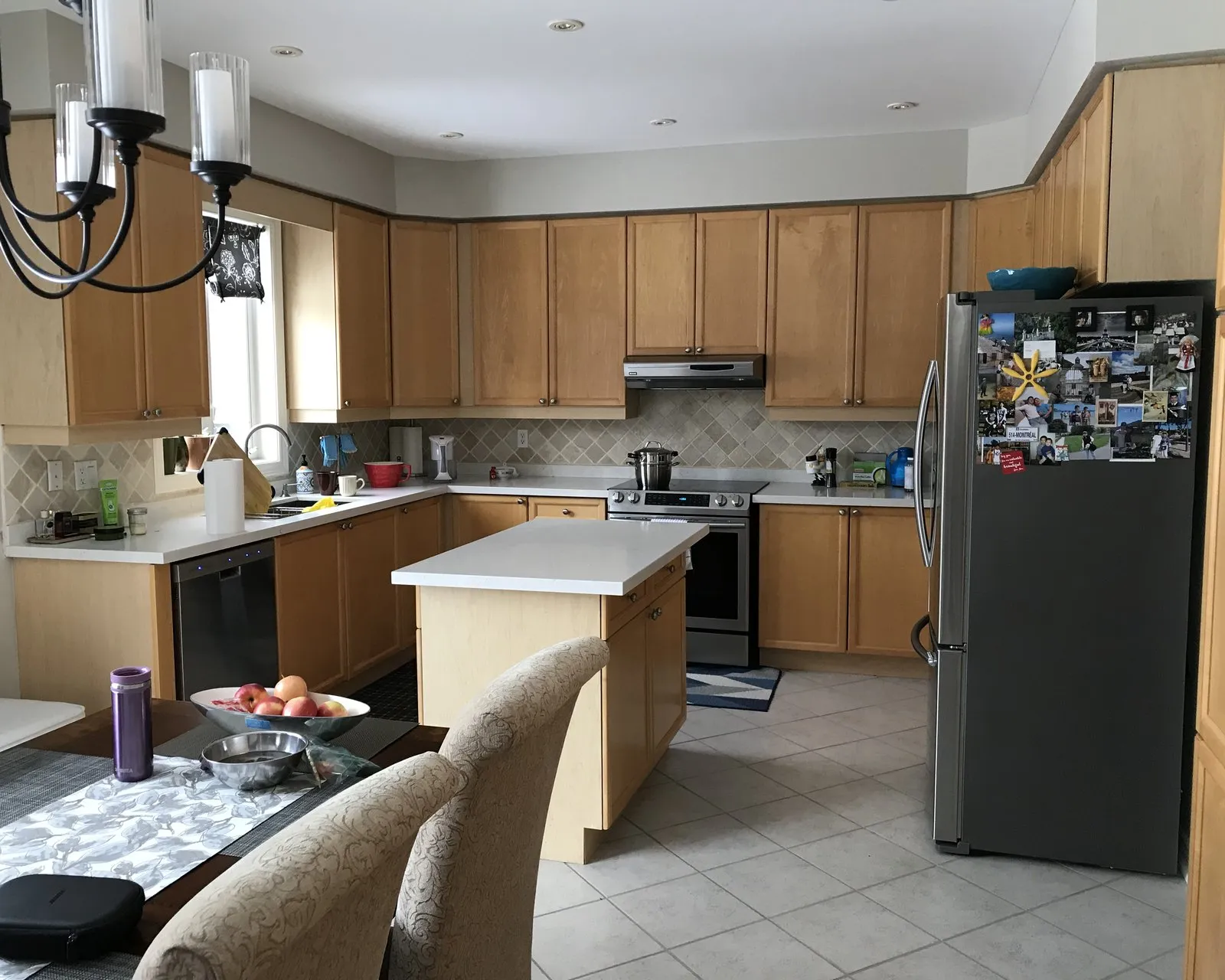 Before — A kitchen before and after painting — oak fronts finished in a soft grey, with the island, the layout and the counters unchanged