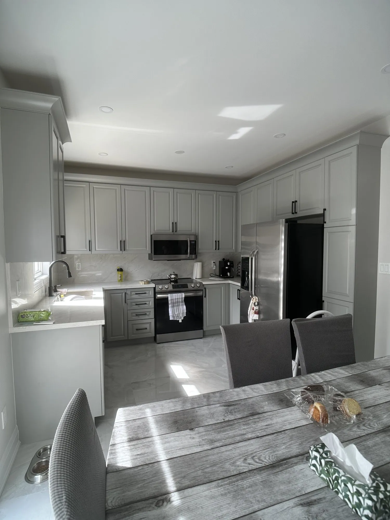 After — oak sprayed Platinum Gray, crown moulding added, matte black handles in Vellore Village, Vaughan