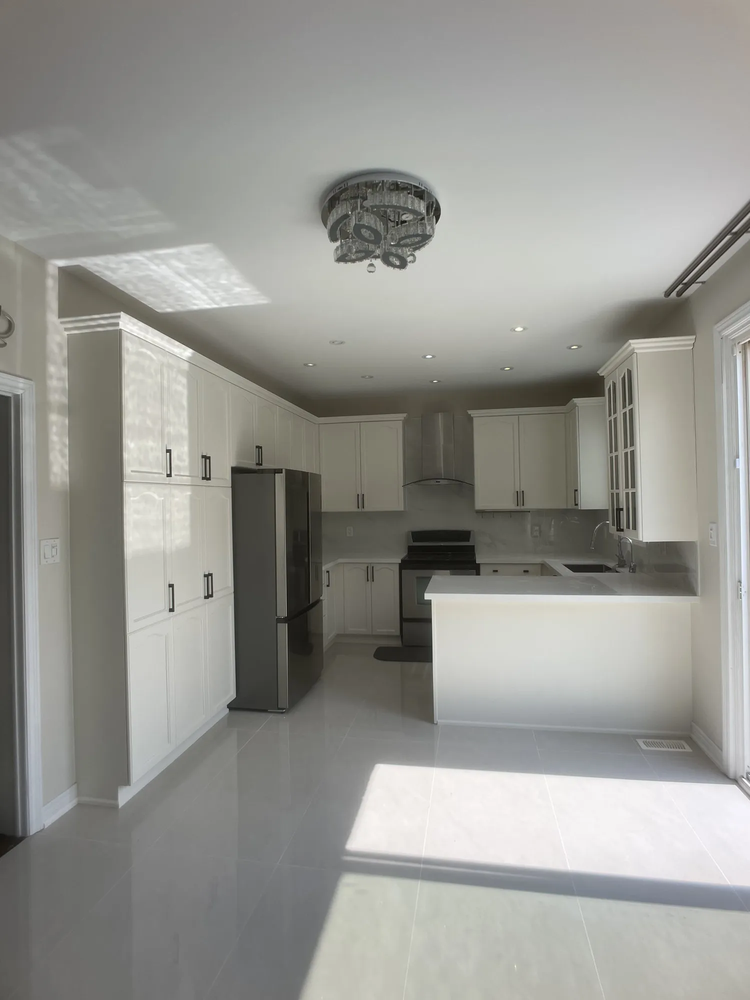 The finished kitchen in white, the original layout, counters, floor and appliances all unchanged