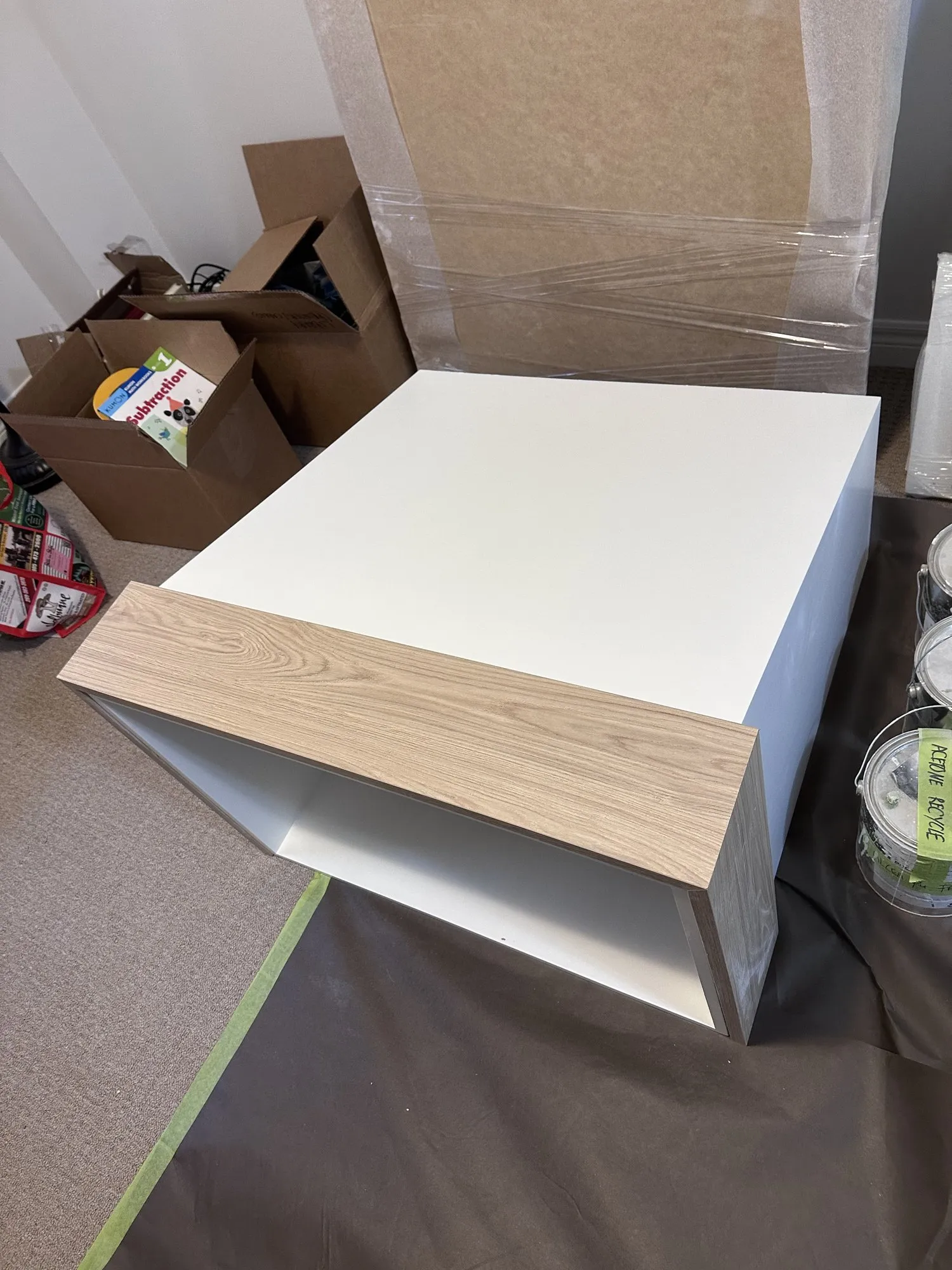 The new range hood box built and standing on the floor, finished white, before it was lifted onto the wall