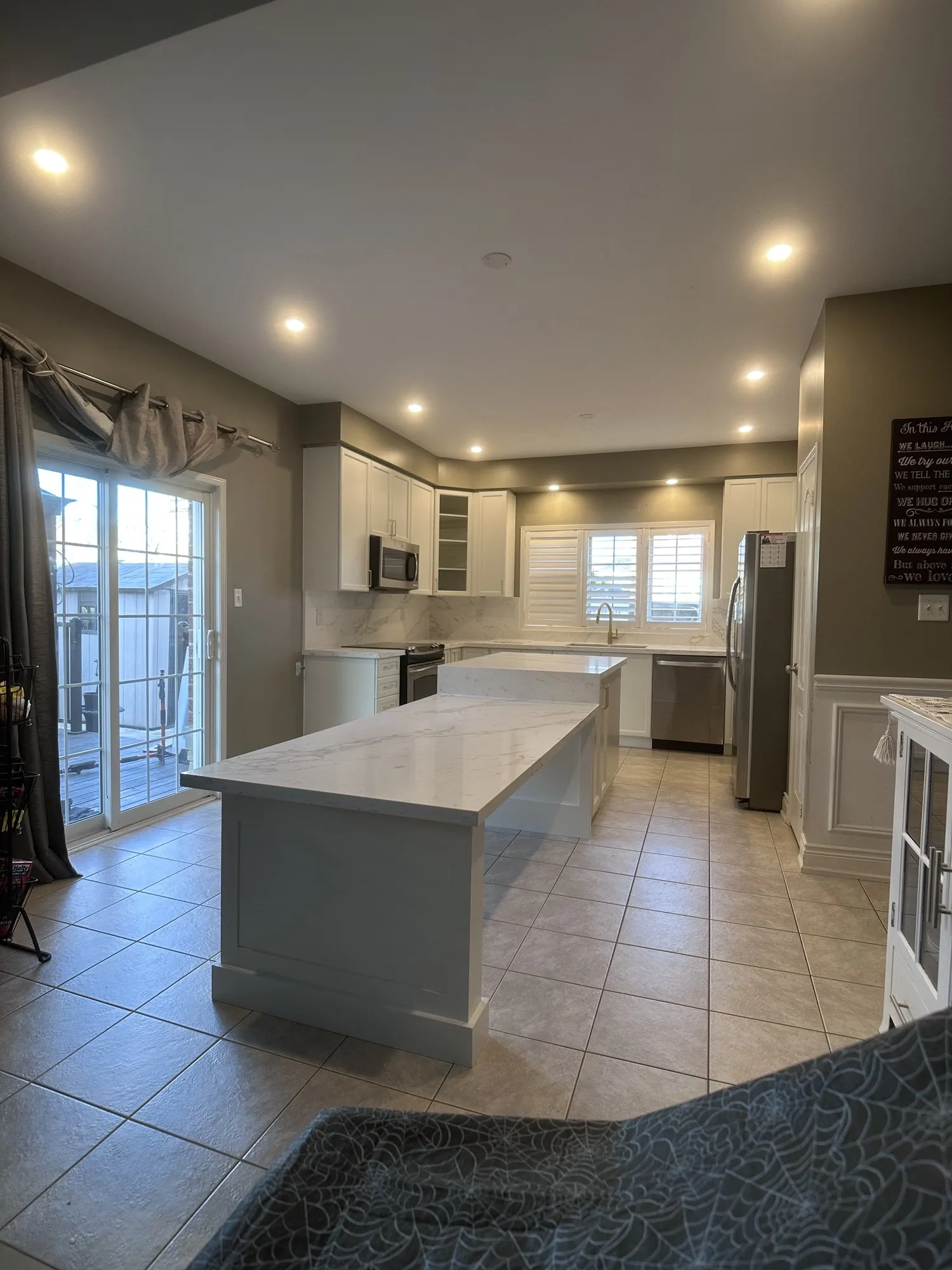 After — Cabinet refinishing in Northeast Ajax — a dark espresso kitchen sprayed white, with the existing island extended by one cabinet under a single run of quartz