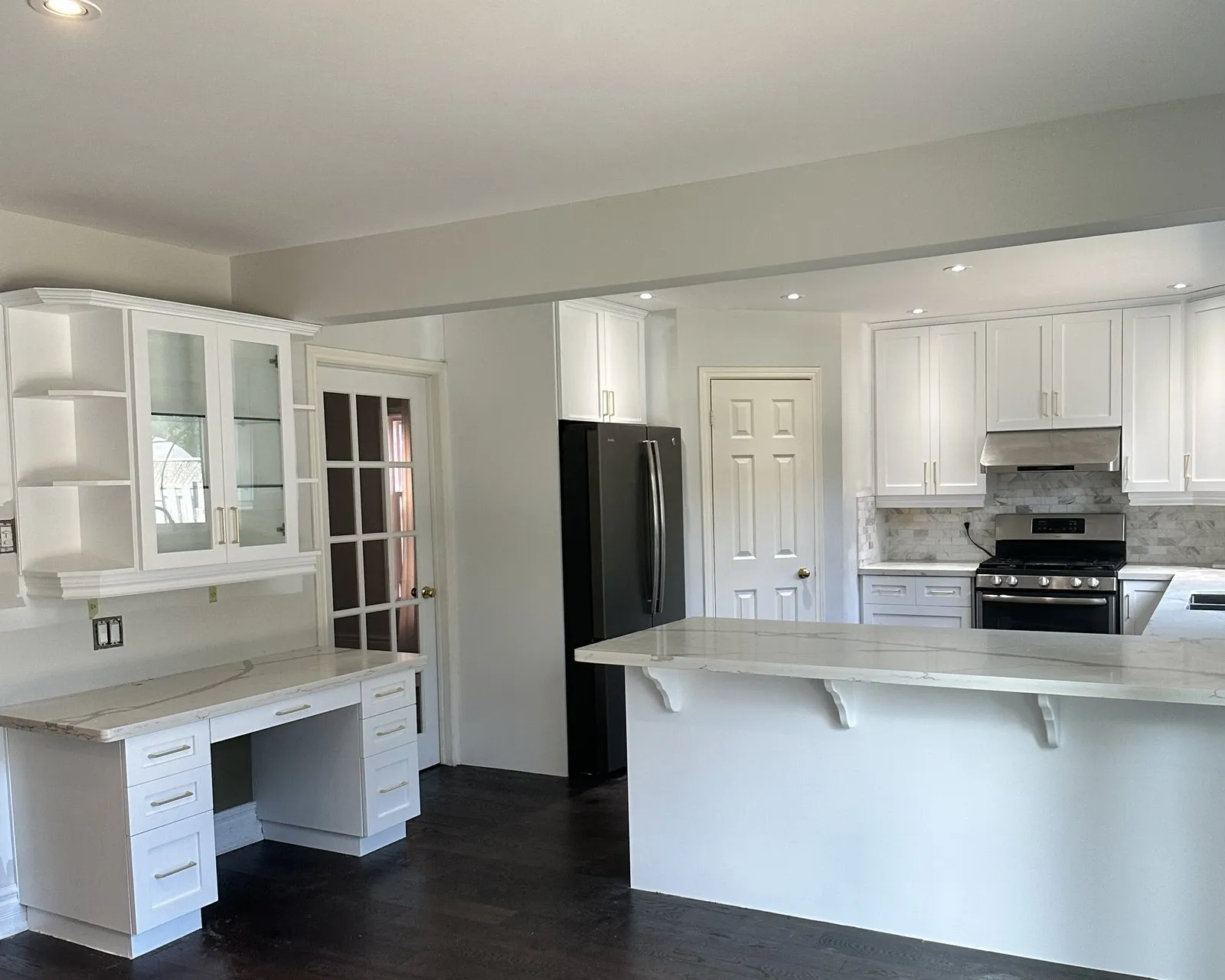 A finished kitchen with a stone-topped peninsula, the cabinets fitted and settled before the run was templated