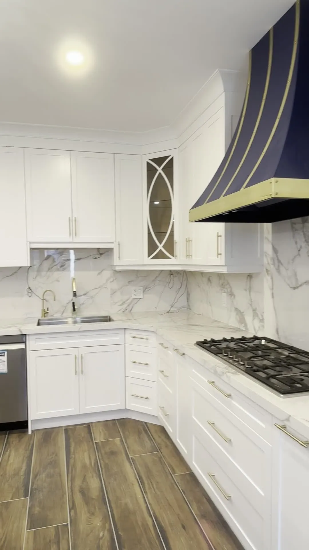 A walk around the finished Vellore Village kitchen — white perimeter cabinetry with a navy island, mullion glass doors, brass handles and a navy hood