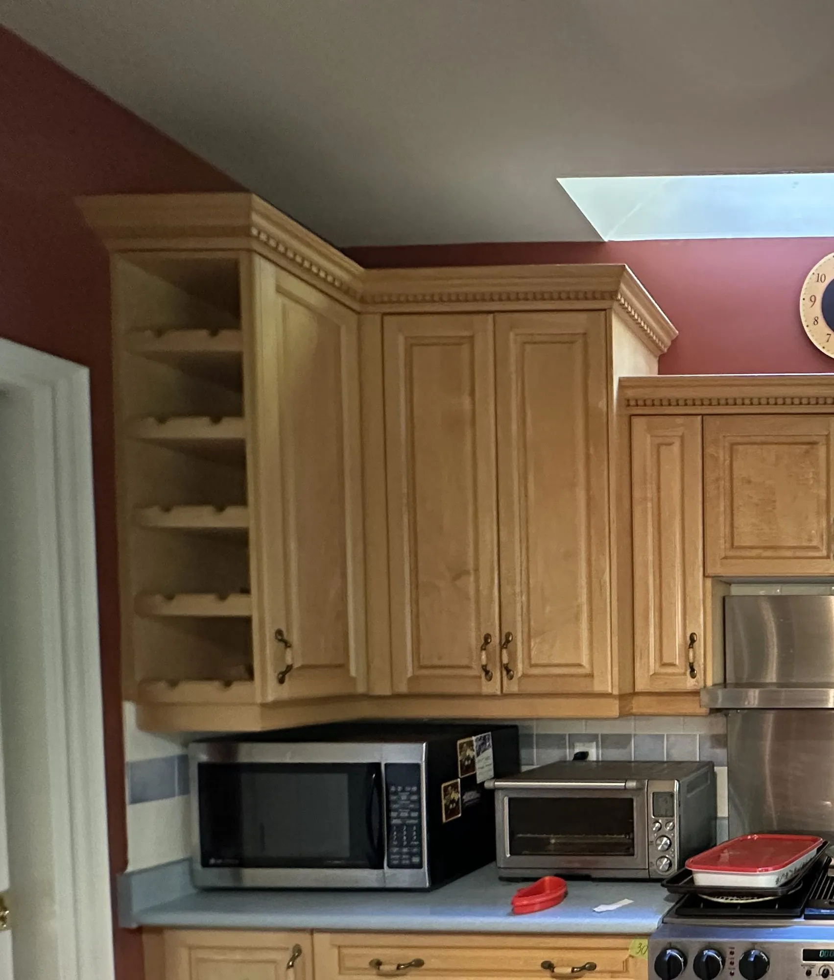 The original honey maple range wall, with a five-tier wine rack built into the end of the upper run and a cabinet above the range