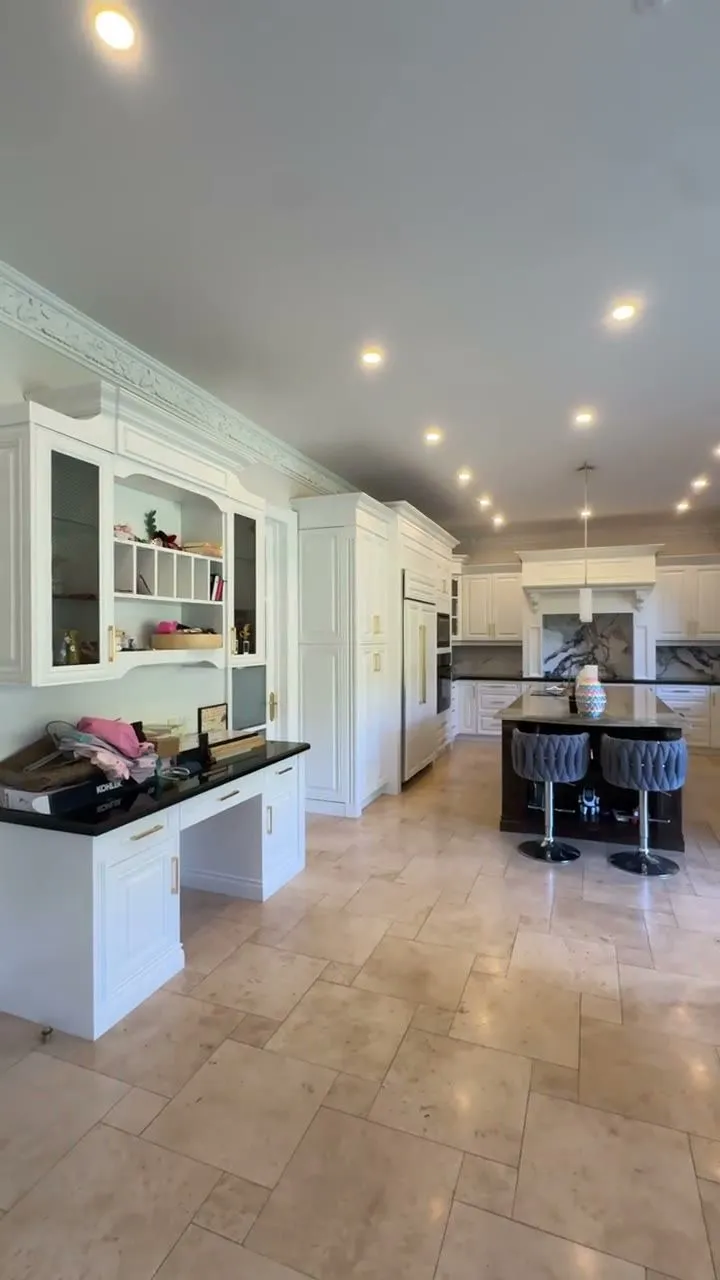 Walkthrough of the finished Thornhill kitchen — cream glazed cabinetry sprayed Oxford White with gold bar pulls, black countertops and a granite island