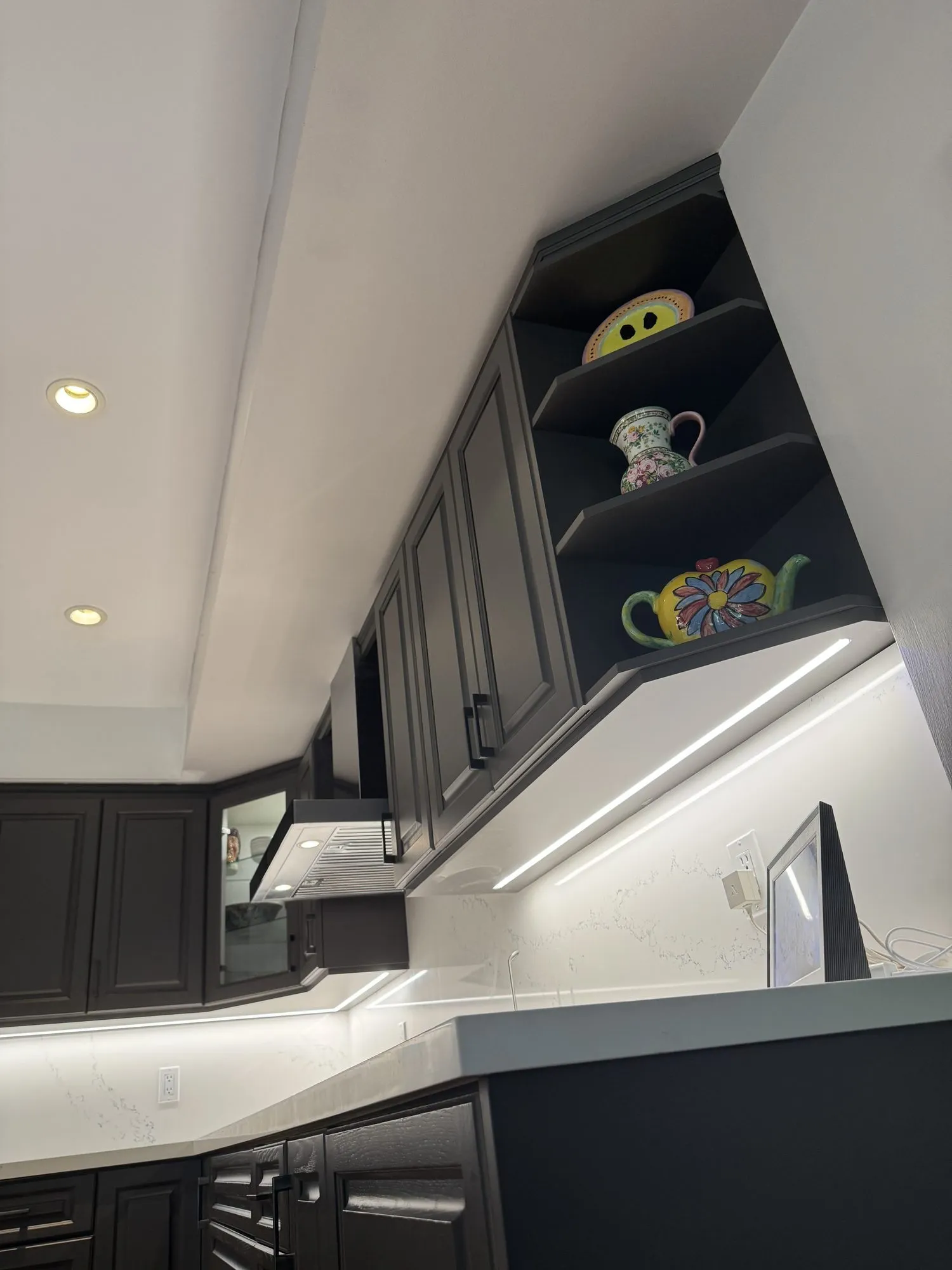 The finished under-cabinet light running along one wall and turning the inside corner in a continuous line, with no break at the mitre