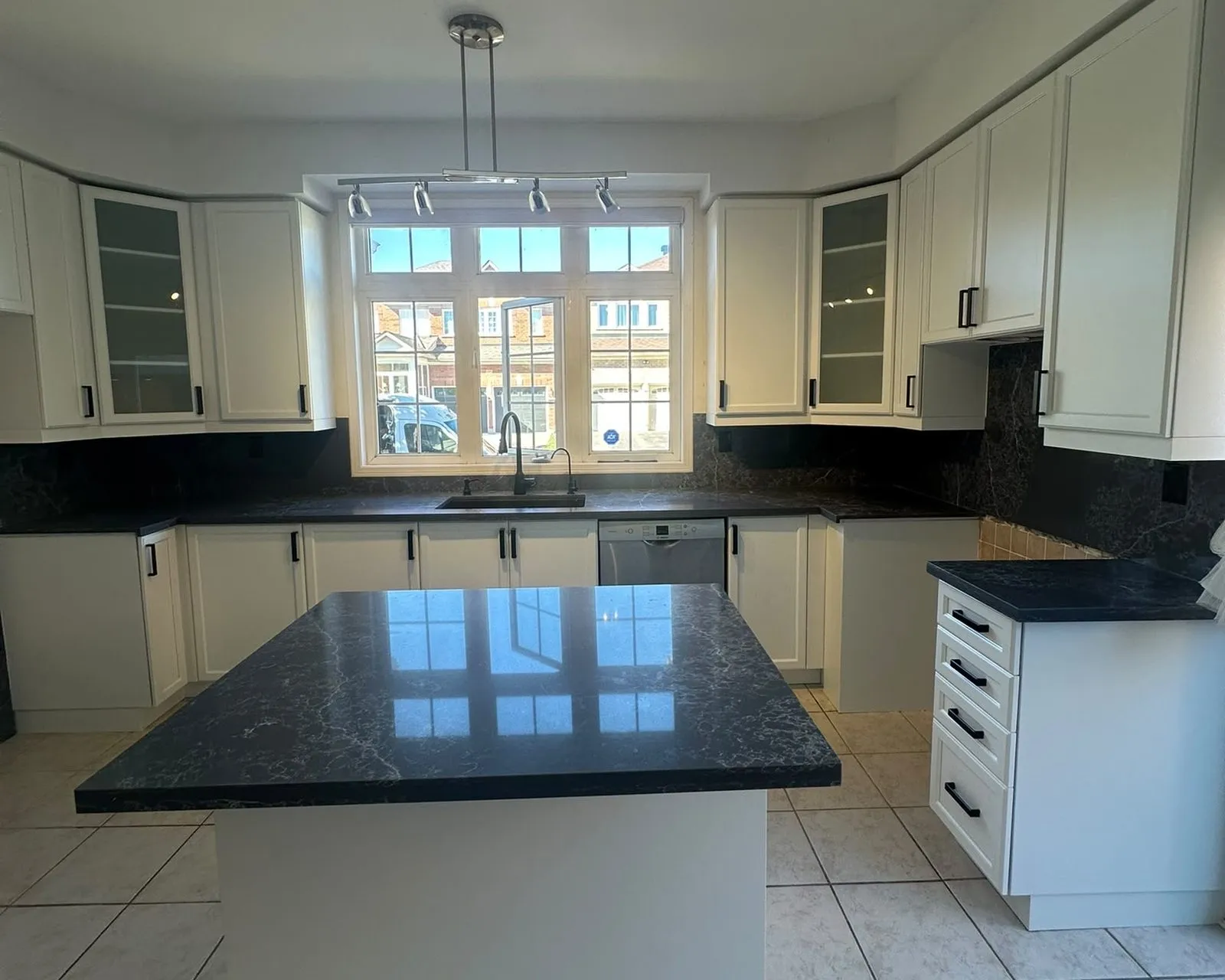 After — dark cherry sprayed Oxford White, matte black bar pulls, new dark countertops and backsplash arranged in Wismer, Markham