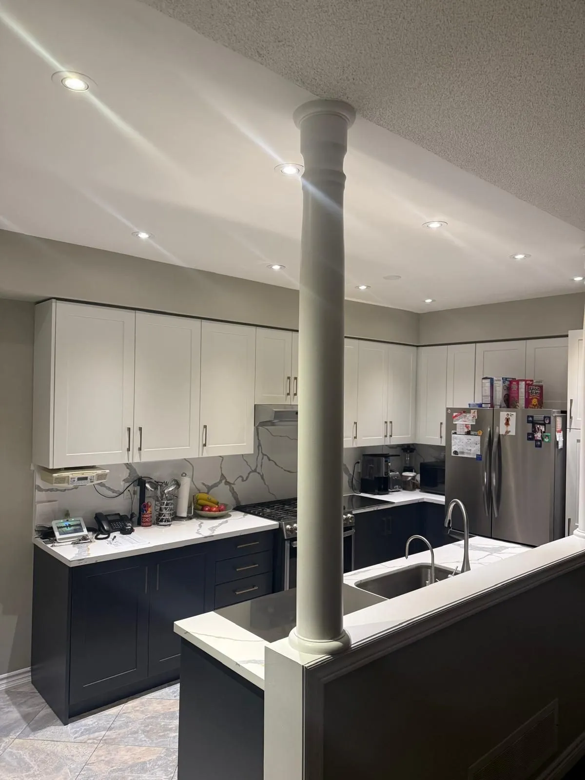 Quartz counter with heavy grey veining, the same material carried up the wall behind the range as a full-height backsplash