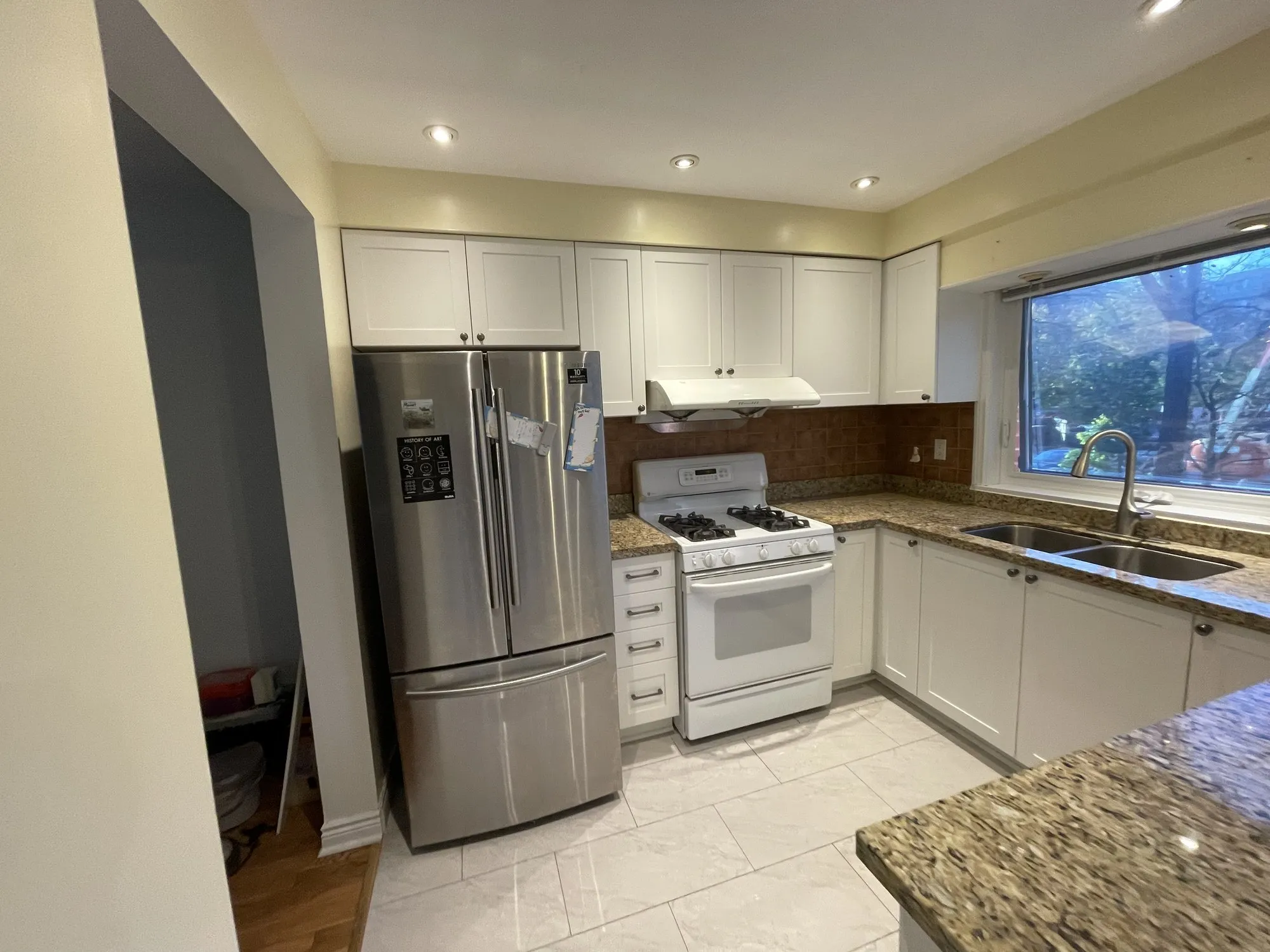 After — flat white doors refaced with MDF shaker fronts, granite and layout kept in Erindale, Mississauga