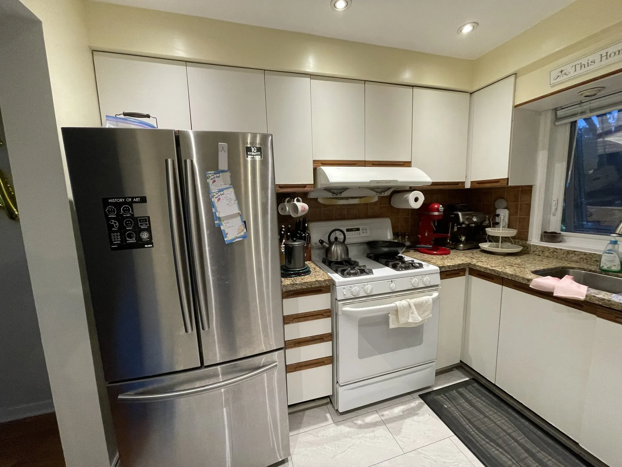Before — flat white doors refaced with MDF shaker fronts, granite and layout kept in Erindale, Mississauga