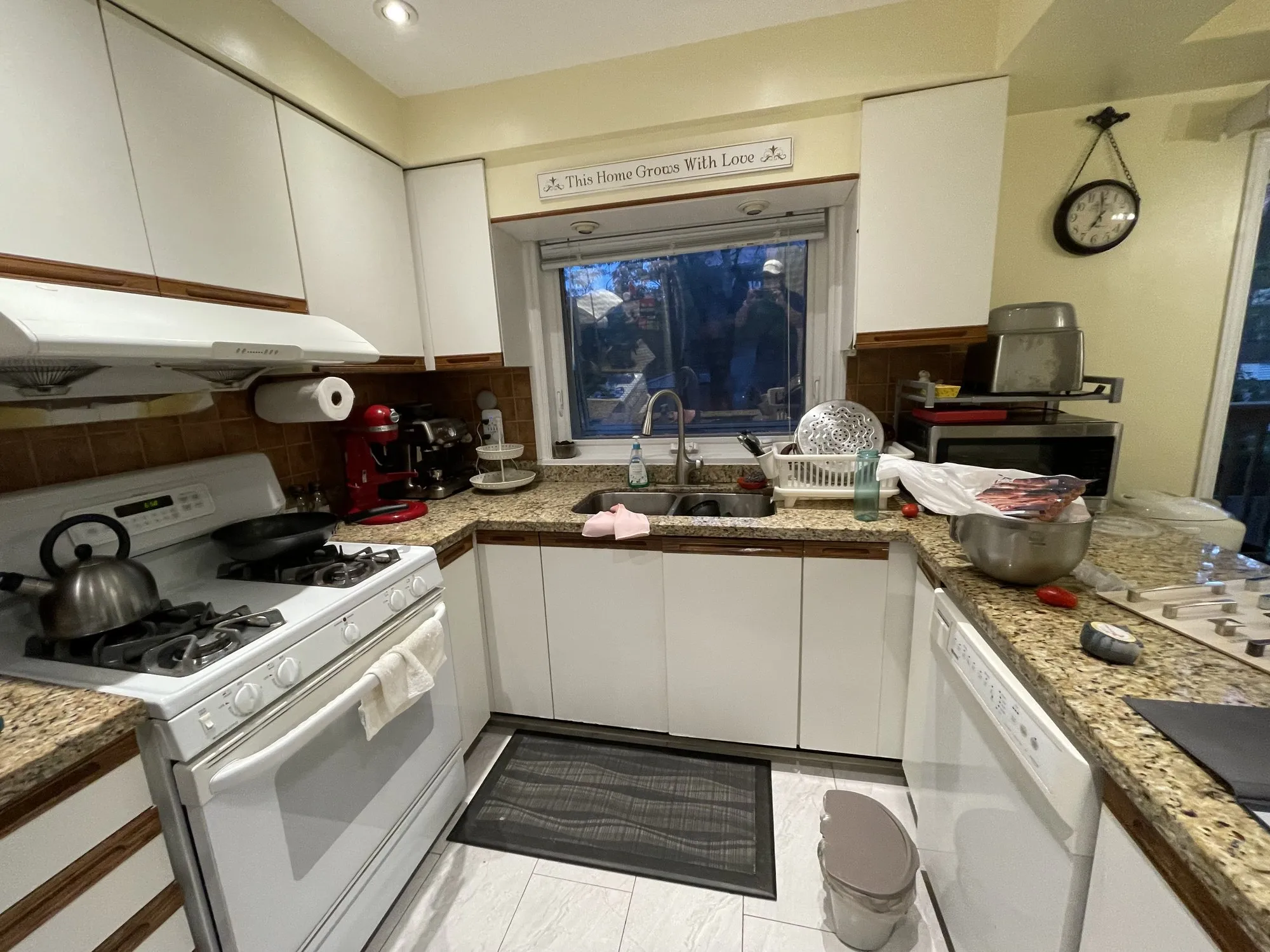 The original kitchen with flat white slab doors and a strip of oak banding running along the top of the upper cabinets and the bottom of the base cabinets