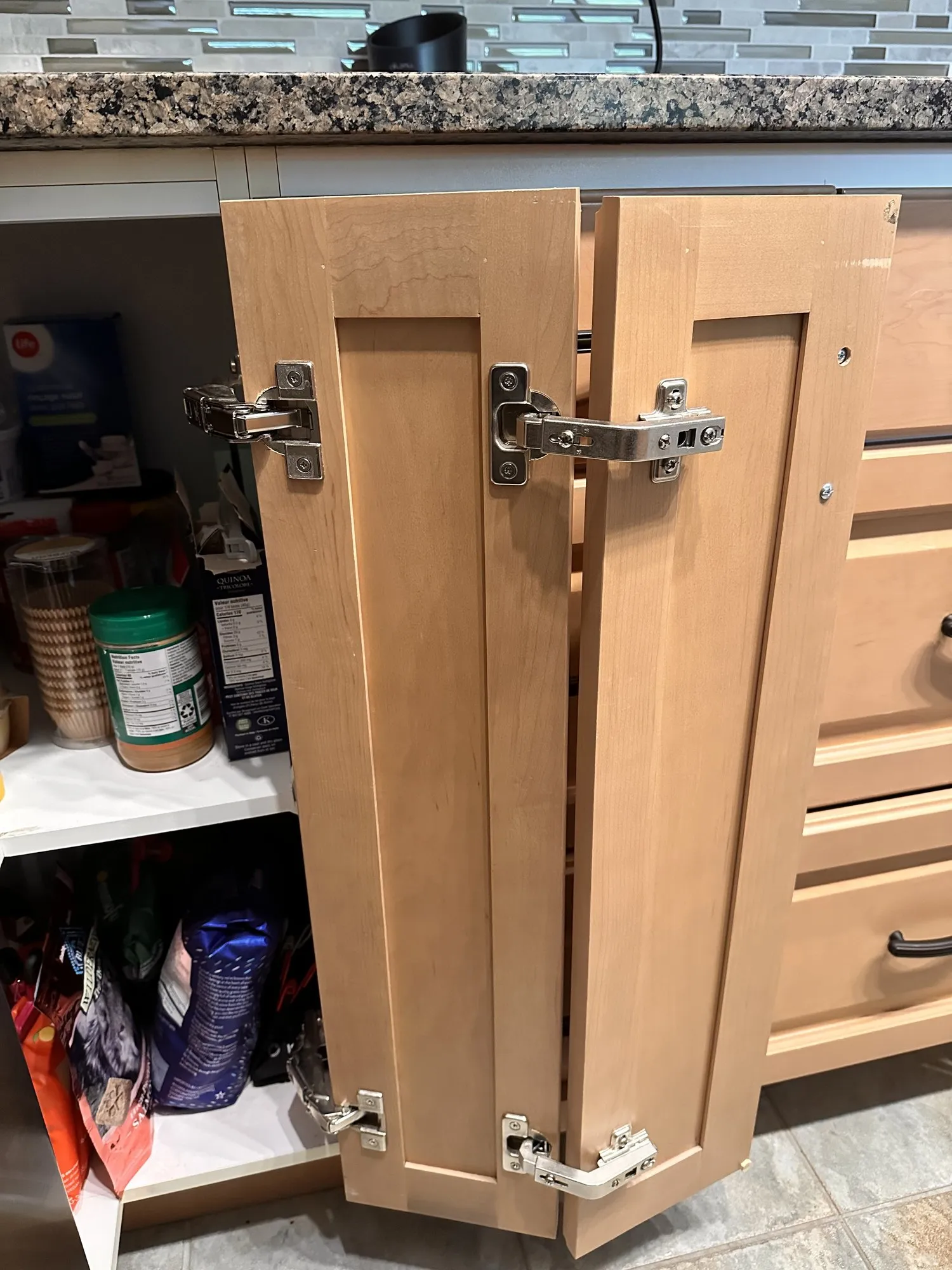 An original maple corner cabinet standing open before the work, the old hinges visible on the door and the carcase