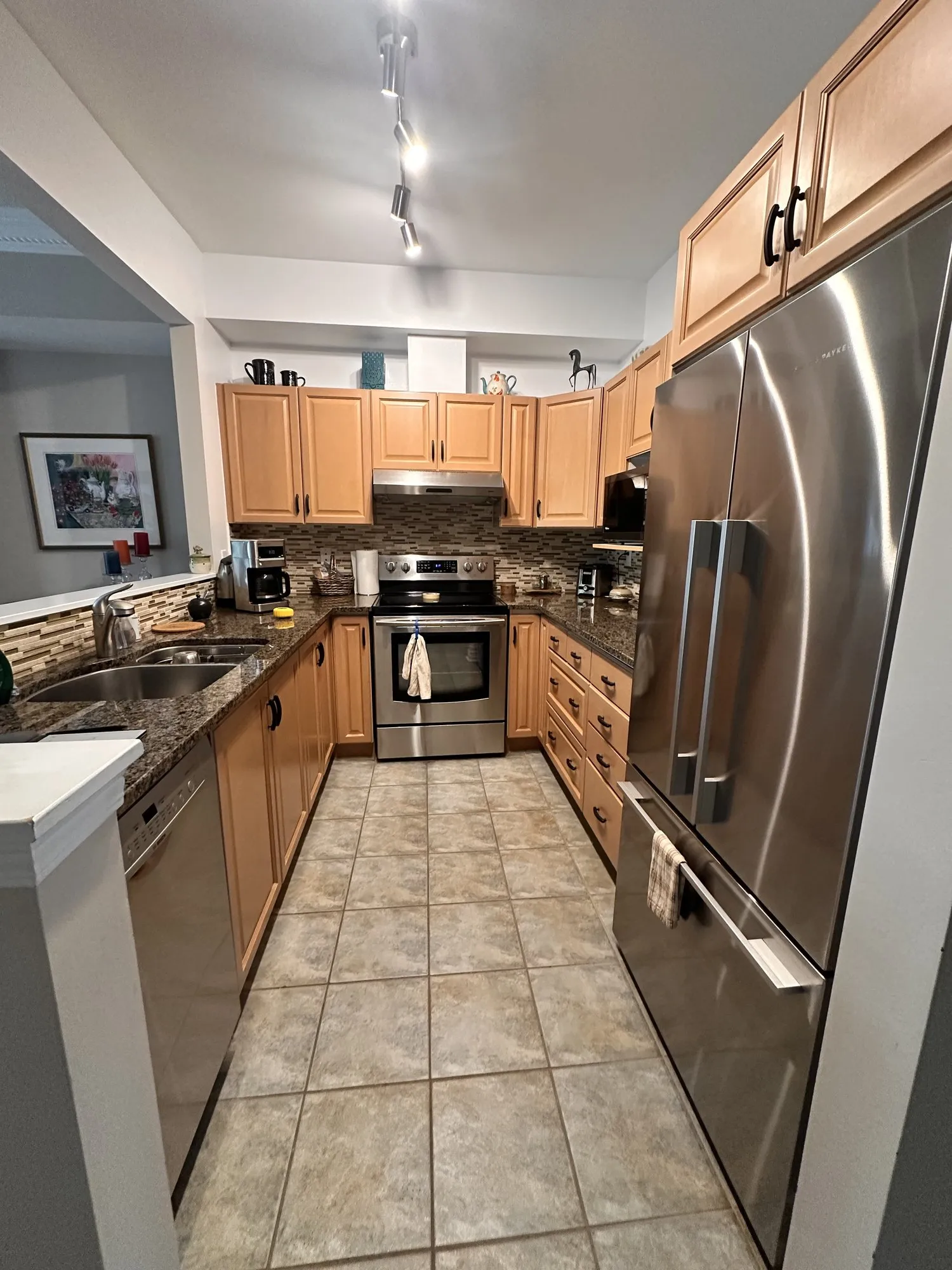 The kitchen before work, maple doors along the galley with the range on the left and the fridge standing at the end of the run
