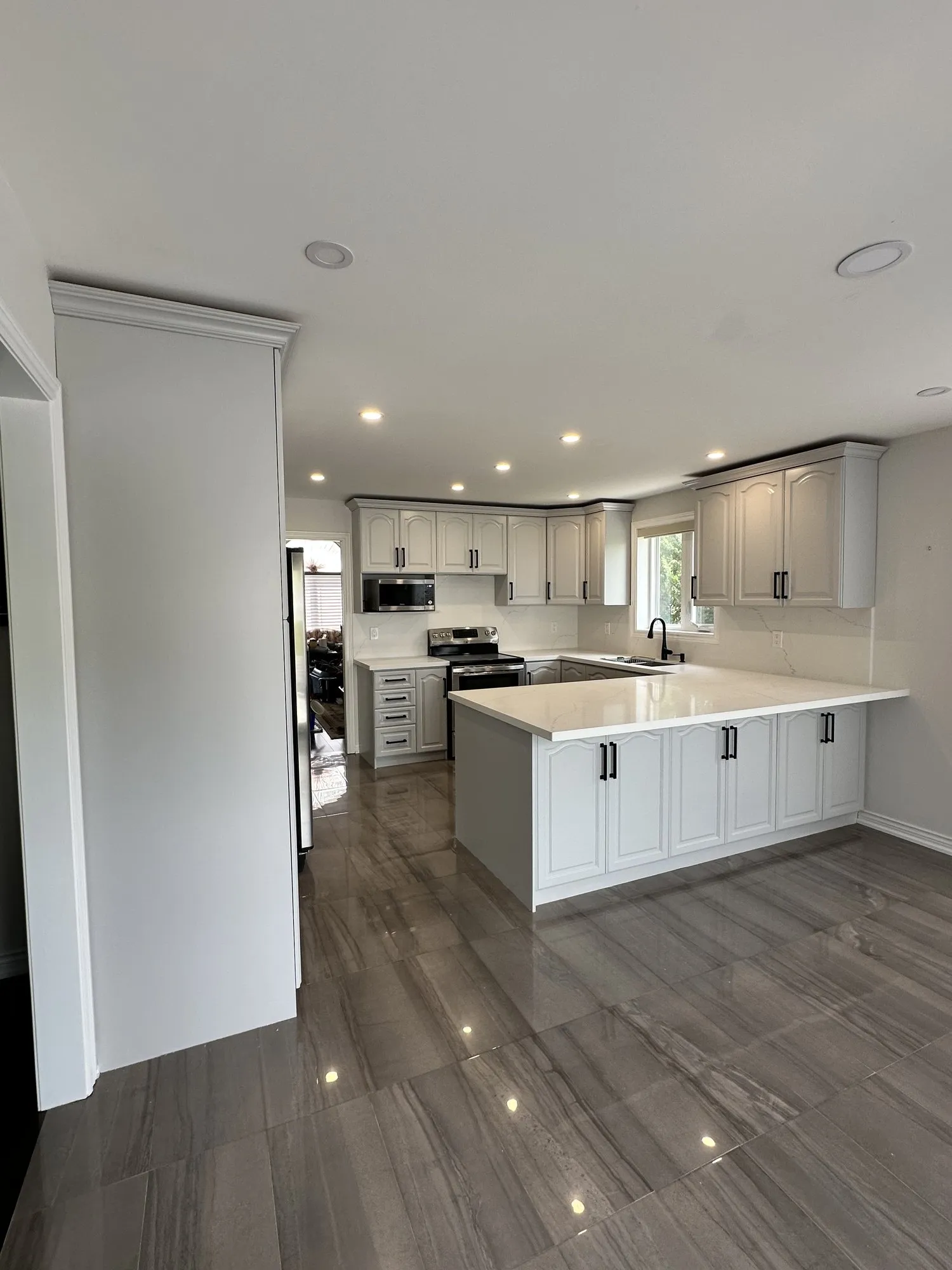 The finished kitchen with solid white doors in the openings that previously held glass, the cathedral arch profile matched across old doors and new