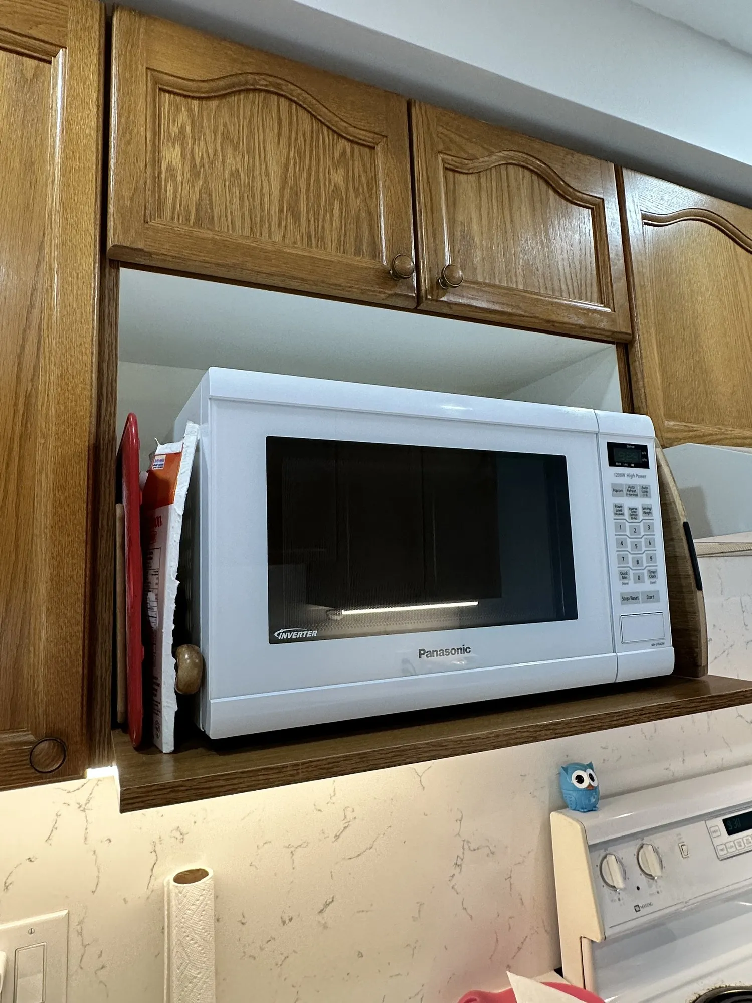 The original oak uppers with the microwave sitting in an open recess that has no doors on it