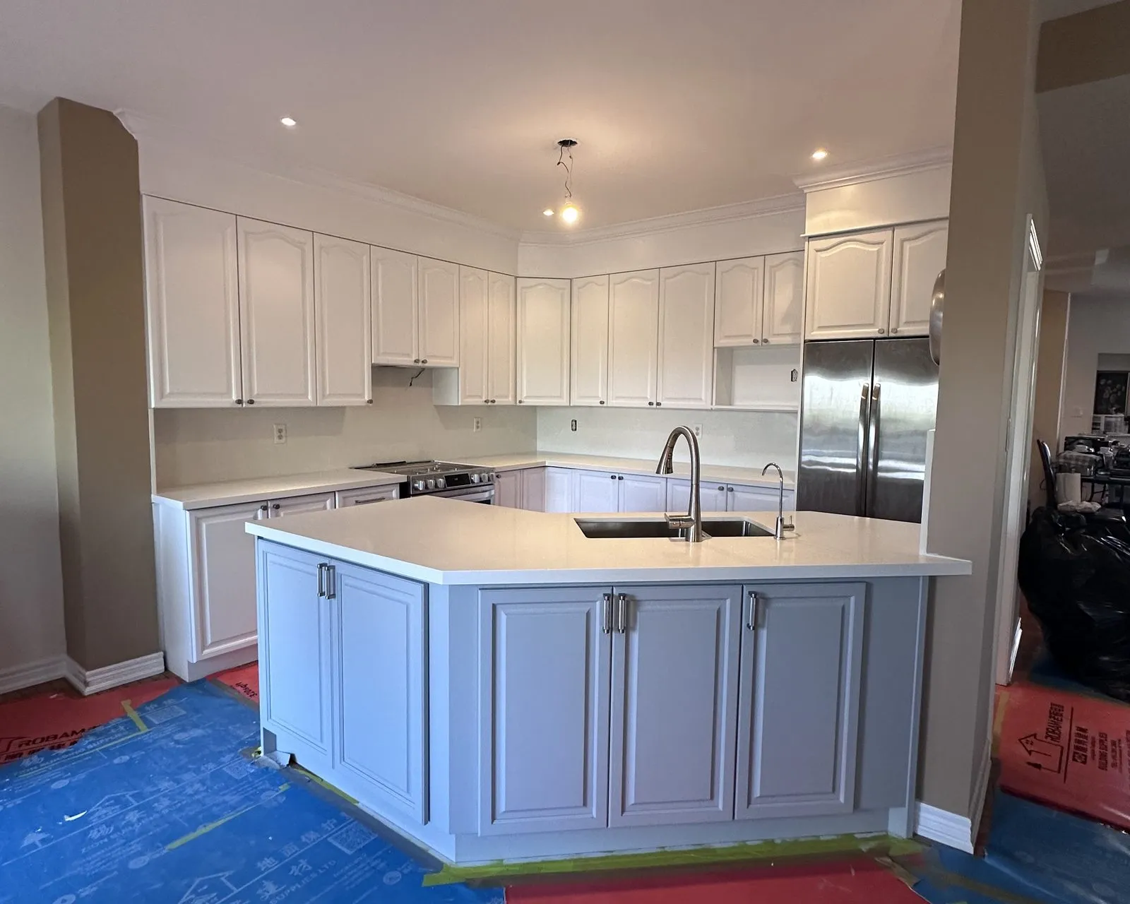 After — counters off, island rebuilt, quartz through and a lighter floor — Glen Oaks, Oakville