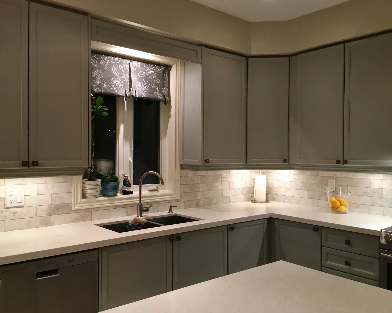A finished run of grey cabinets under a window, the doors and the frames reading as one continuous colour
