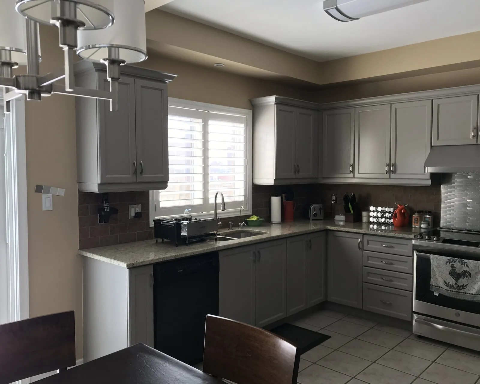 A finished kitchen in soft greige, the doors, drawer fronts and frames all reading as one continuous colour under the wall cabinets
