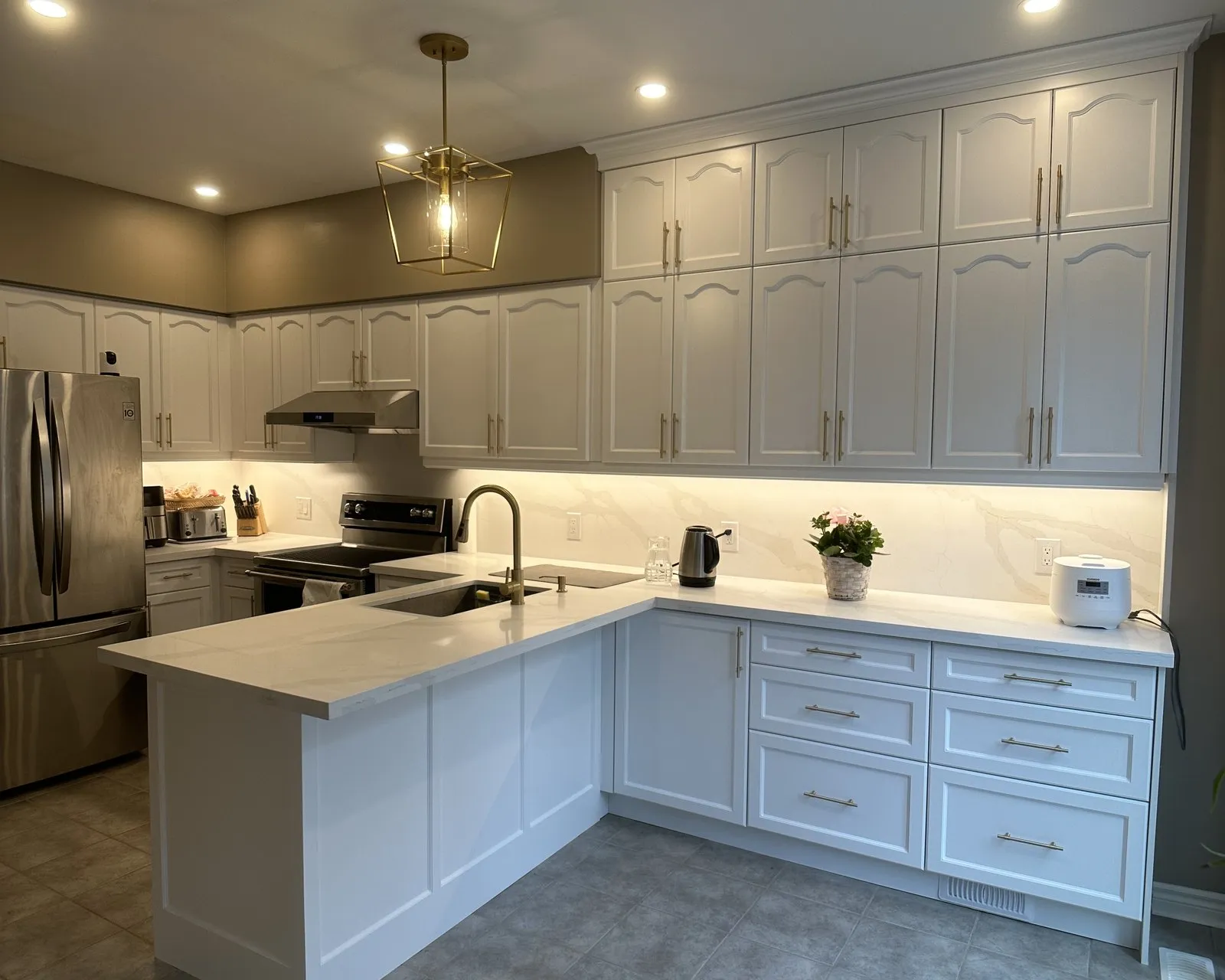 A finished kitchen with new quartz across the run and the peninsula, the stone templated to the cabinets after they were fitted