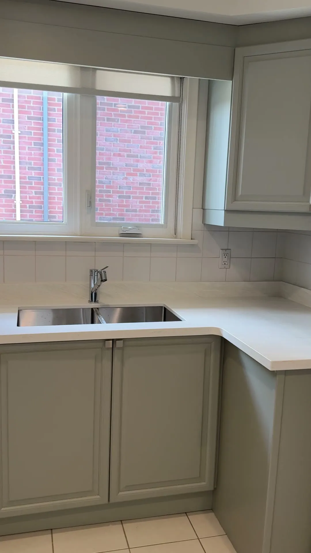 The finished Pelmo Park-Humberlea kitchen — dark walnut cabinetry sprayed a single grey tone, new drawers where the corner cabinets were, and the original tile floor kept