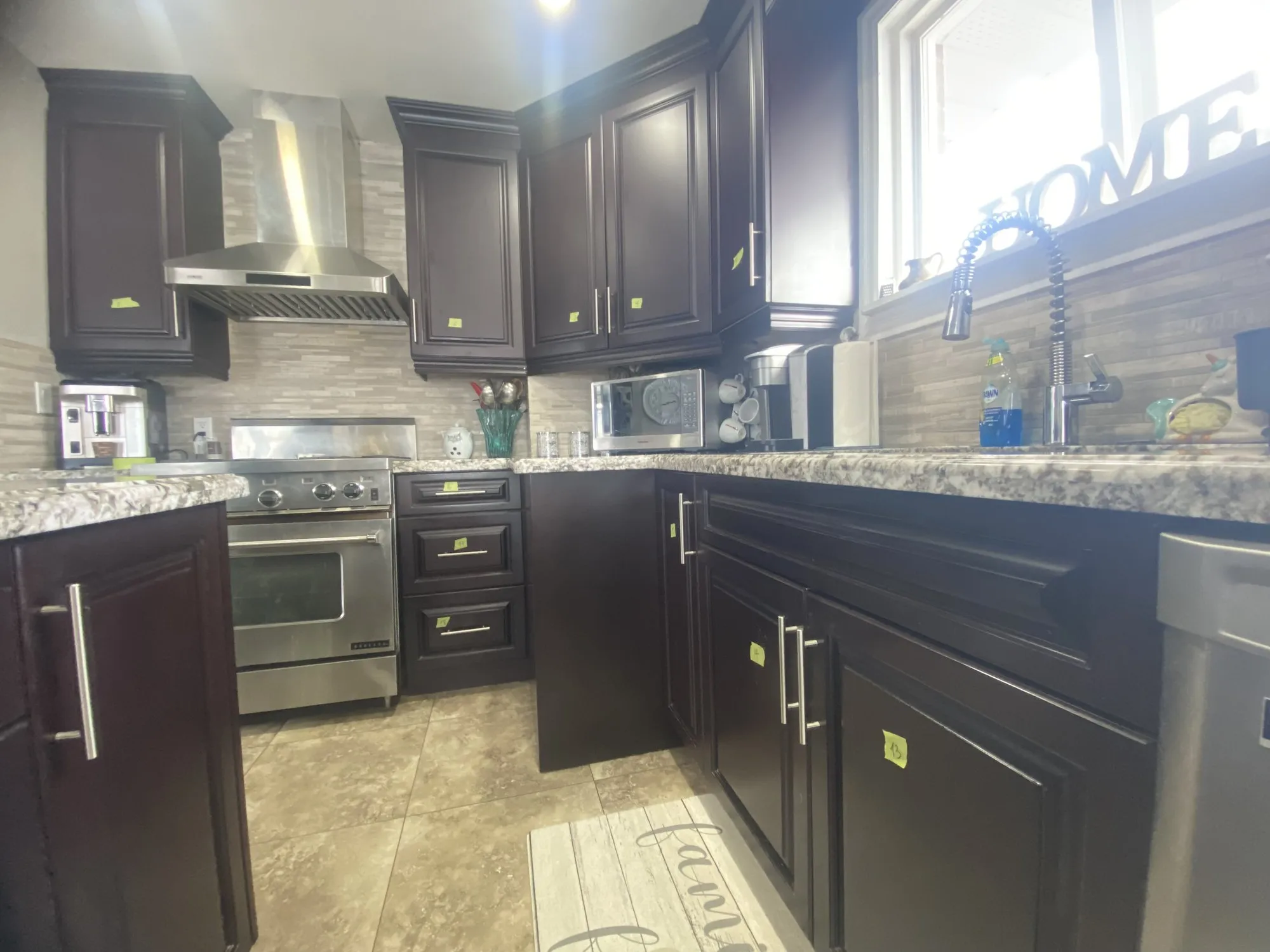 The kitchen before the work, espresso cabinetry running the full perimeter and continuing into a large matching island