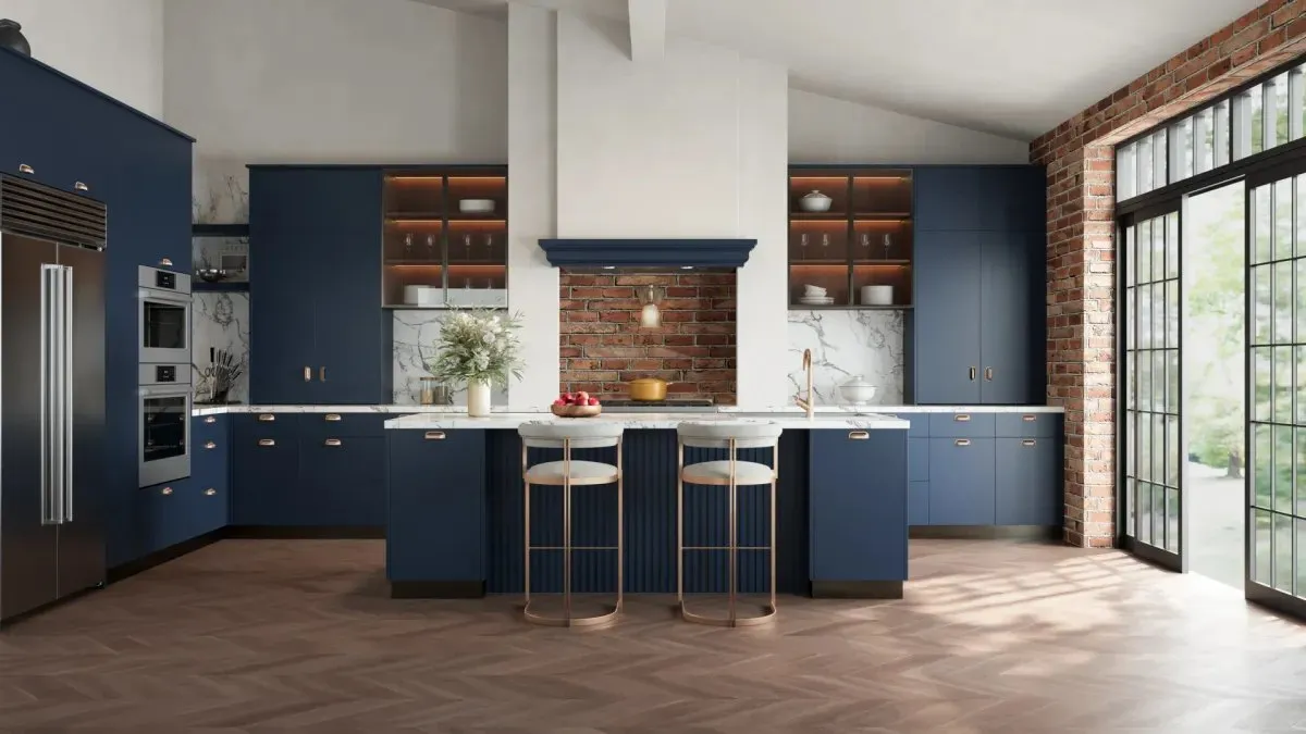 A navy blue flat-slab kitchen with an island, a white chimney hood and a brick feature wall