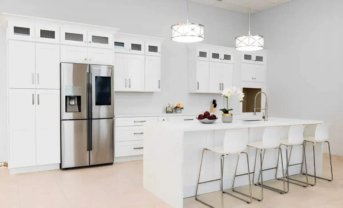 A white shaker kitchen with an island and stools