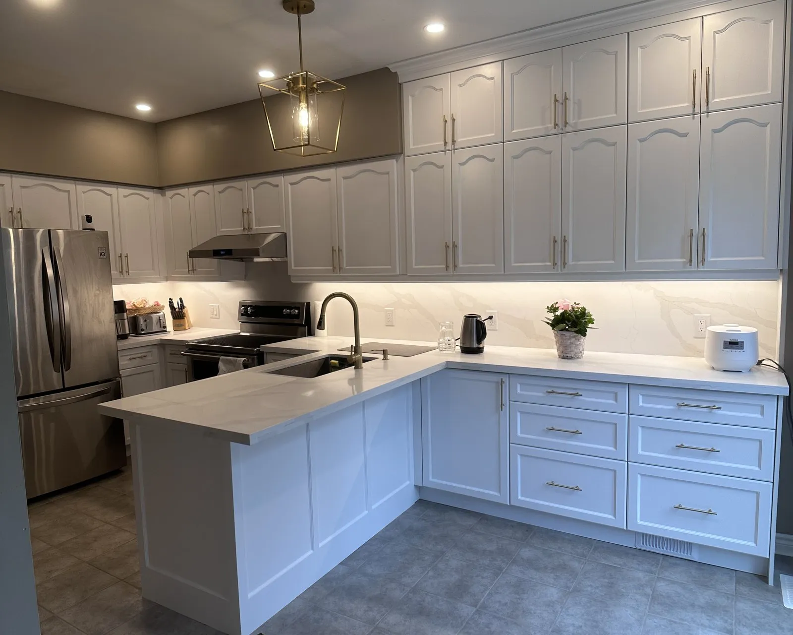 Quartz fitted across a finished run and up the wall as a slab splashback, with the seam placed away from the sink