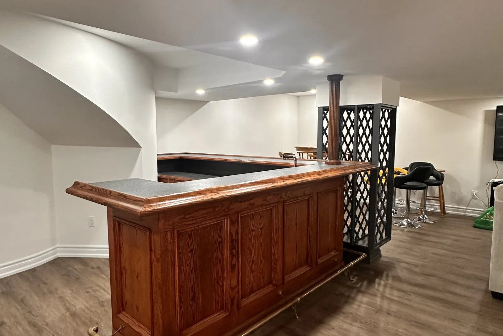 A basement bar in stained oak, the grain reading through a warm clear finish