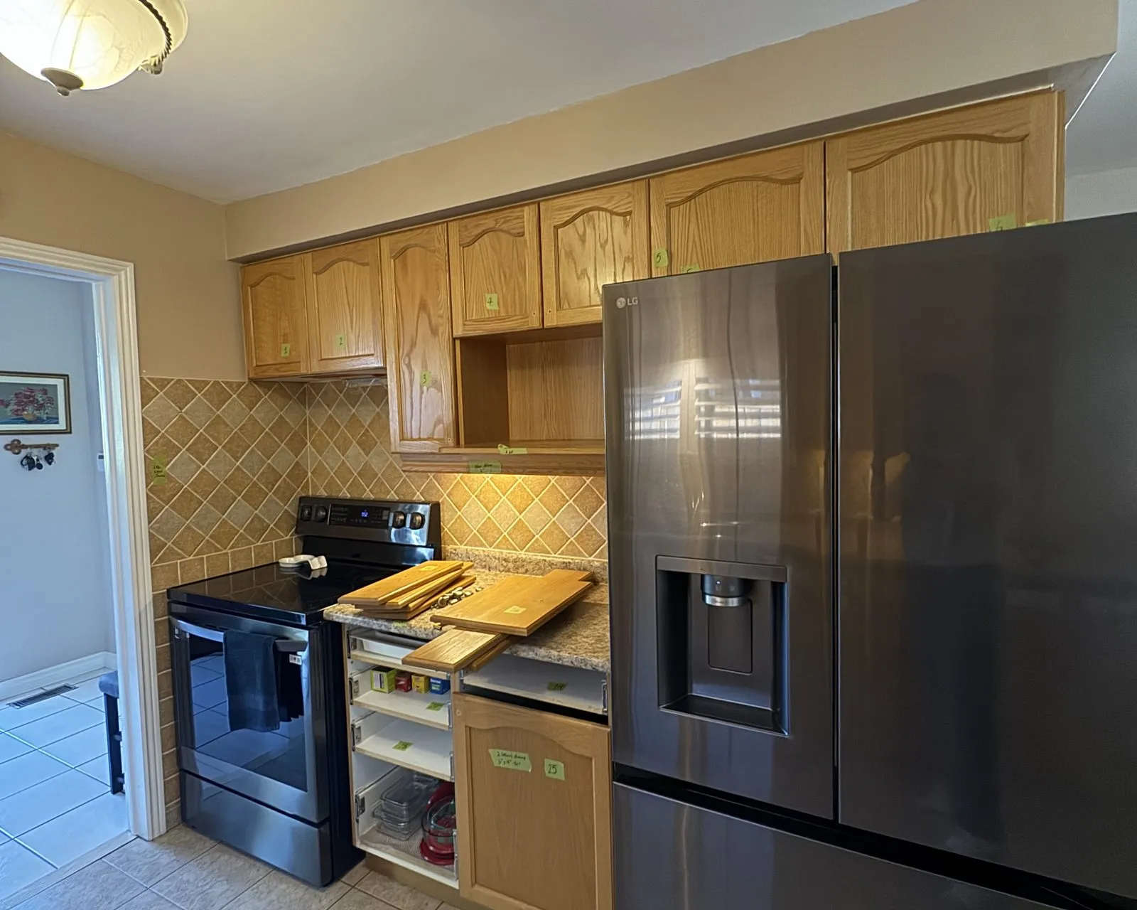 Before — Backsplash installation in Bronte Creek, Oakville — diamond-set travertine tile replaced with a full-height quartz slab run continuously behind the counter