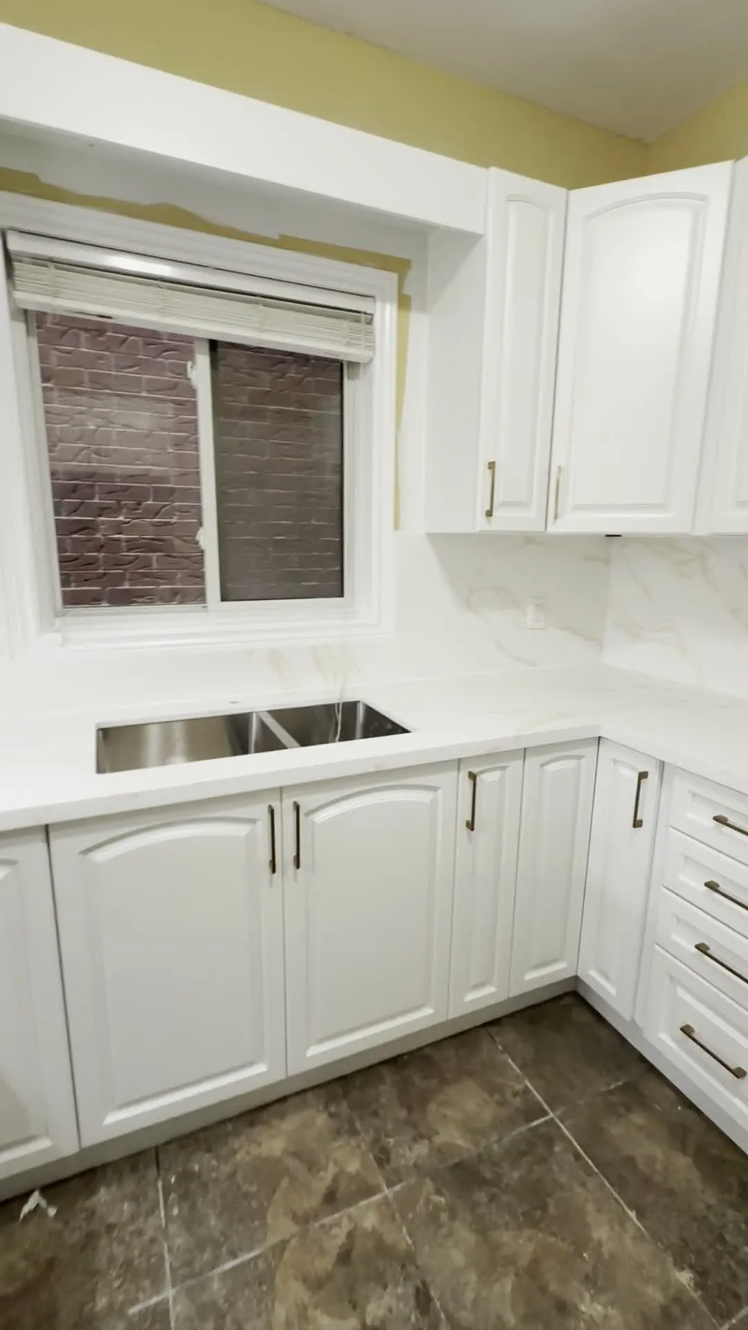 The finished Jerome kitchen — the original arched raised-panel doors sprayed white, with new handles and the same tile floor