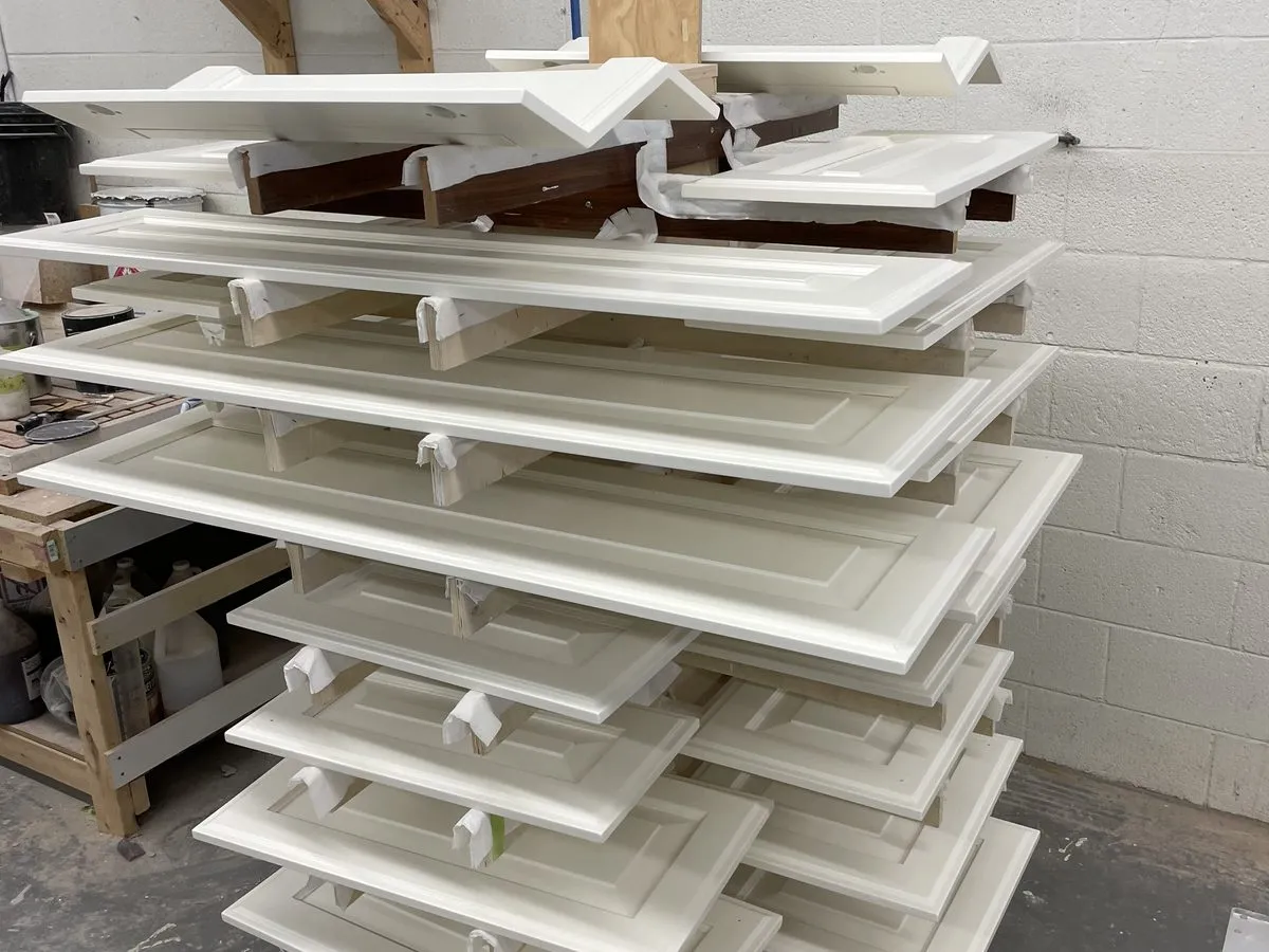 Finished cabinet doors racked on rolling carts in the shop, made and ready to install