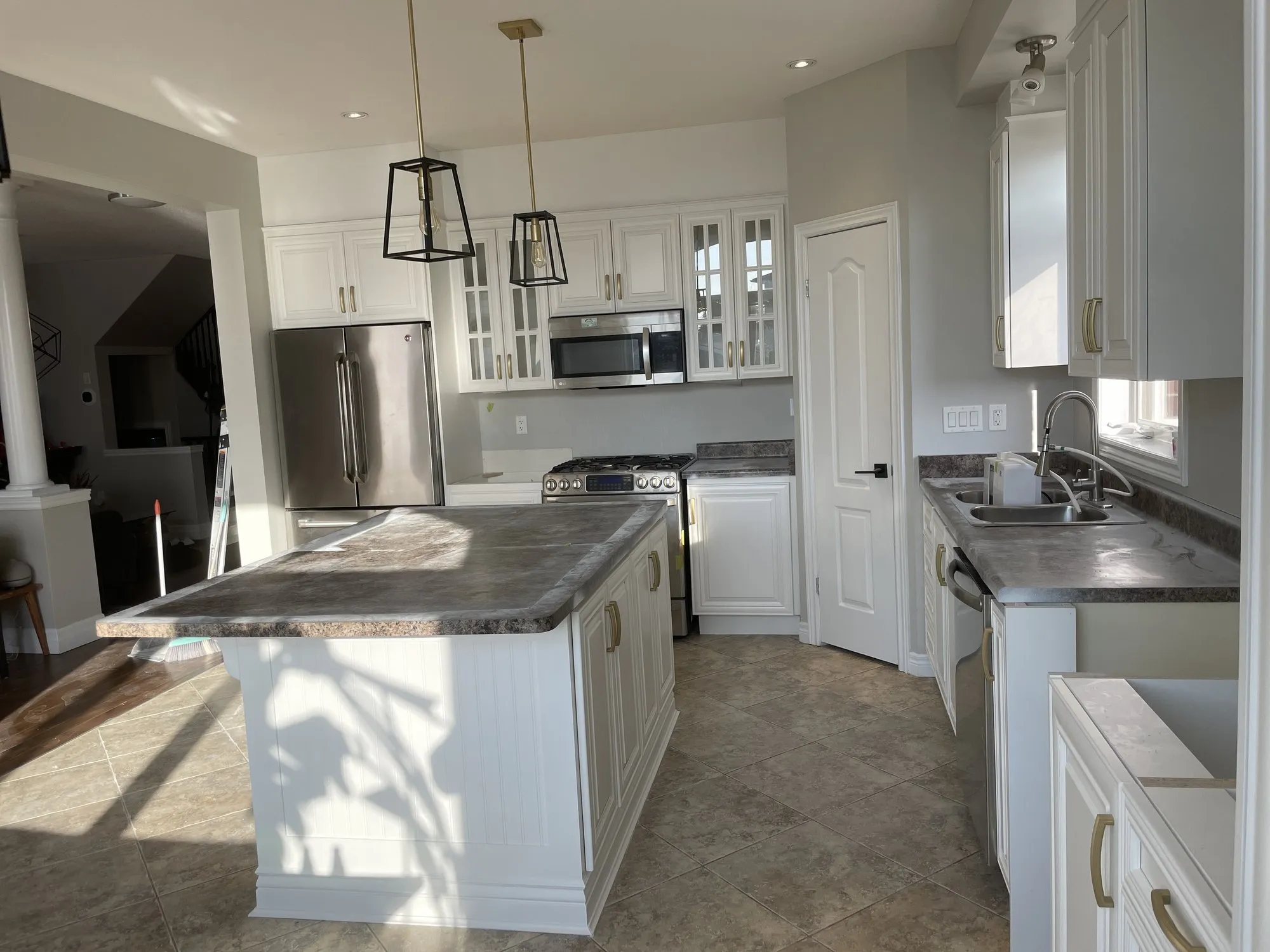 After — cream cabinetry refinished white, counters and layout kept in Stoney Creek, Hamilton