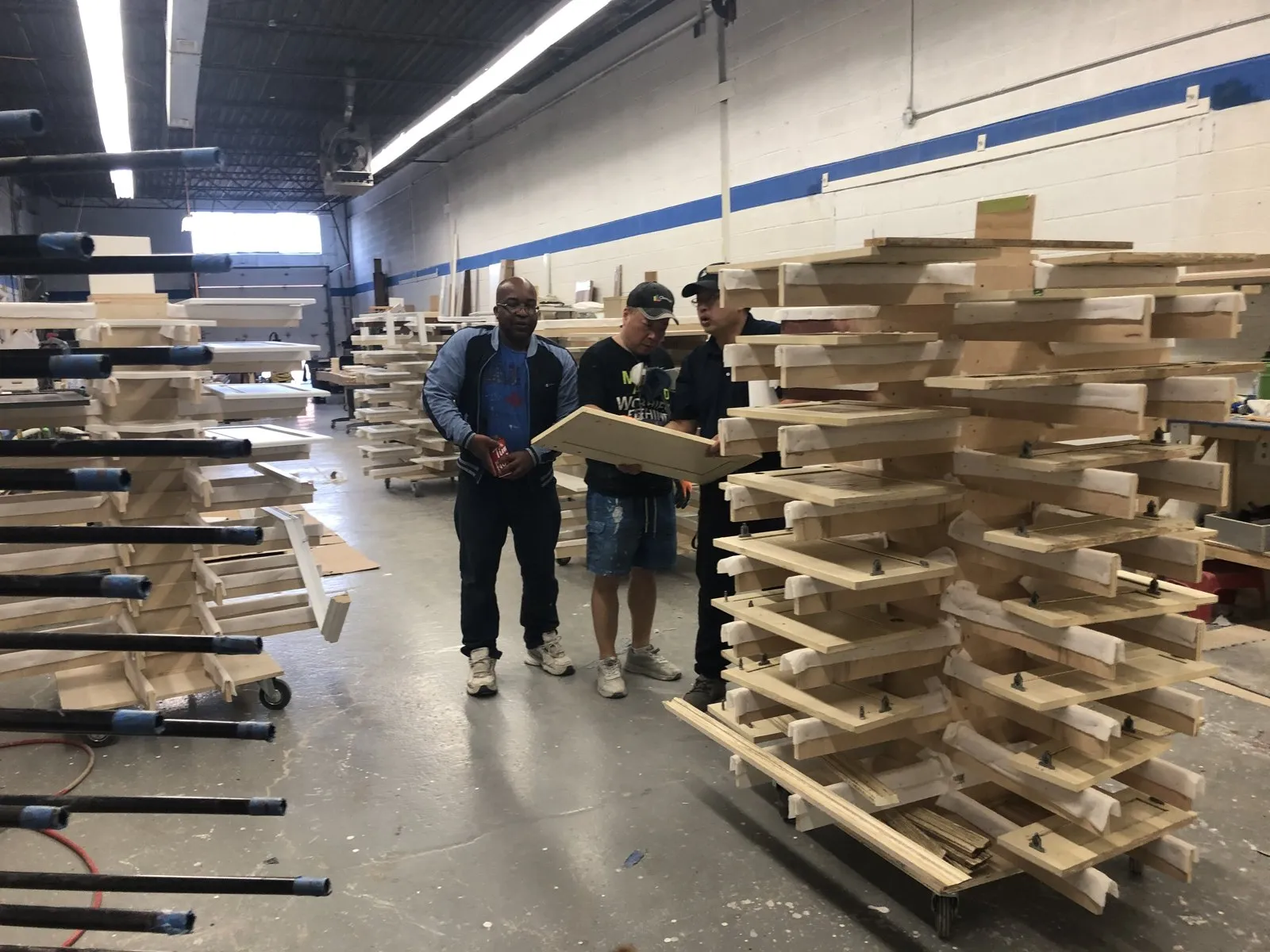 Raw door frames stacked on racks in the shop, checked before they go to finishing