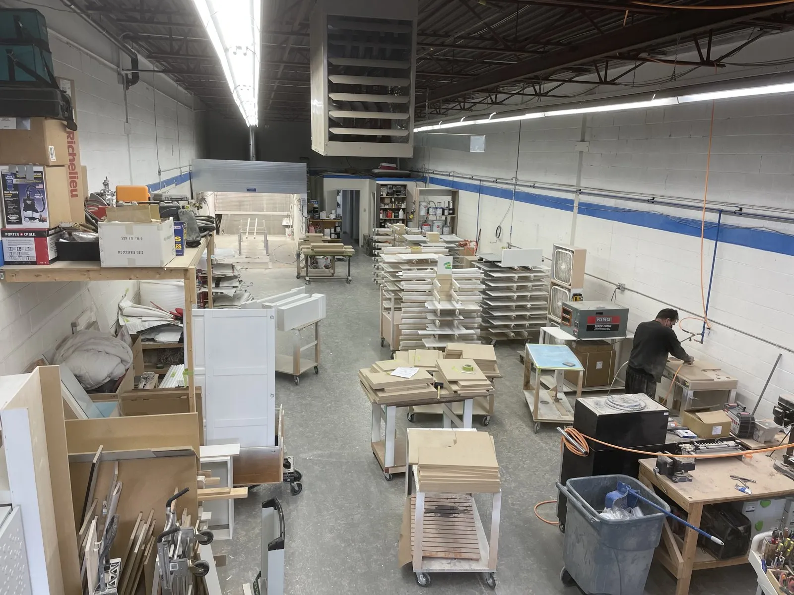 Drawer boxes and cabinet parts on carts in the shop, cut and waiting to be assembled