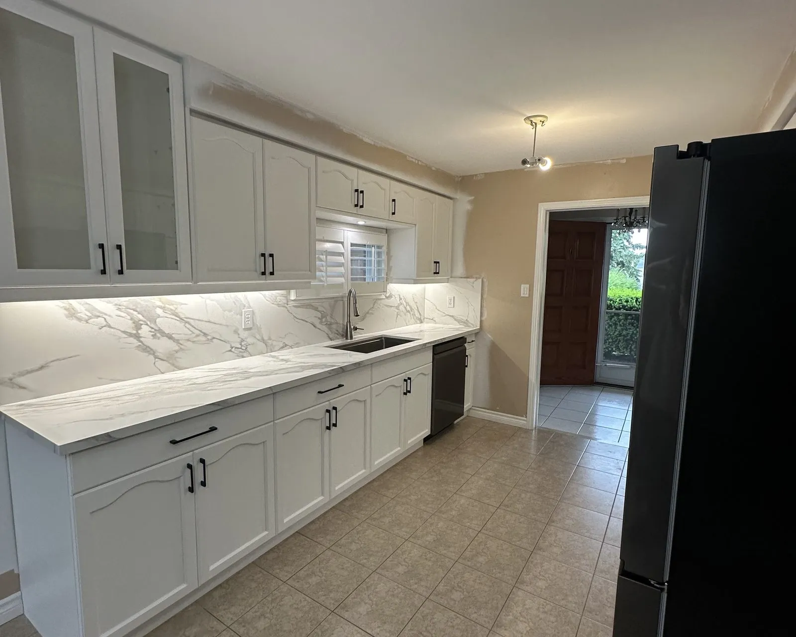 After — golden oak sprayed white, new quartz and a slab backsplash — Bronte Creek, Oakville