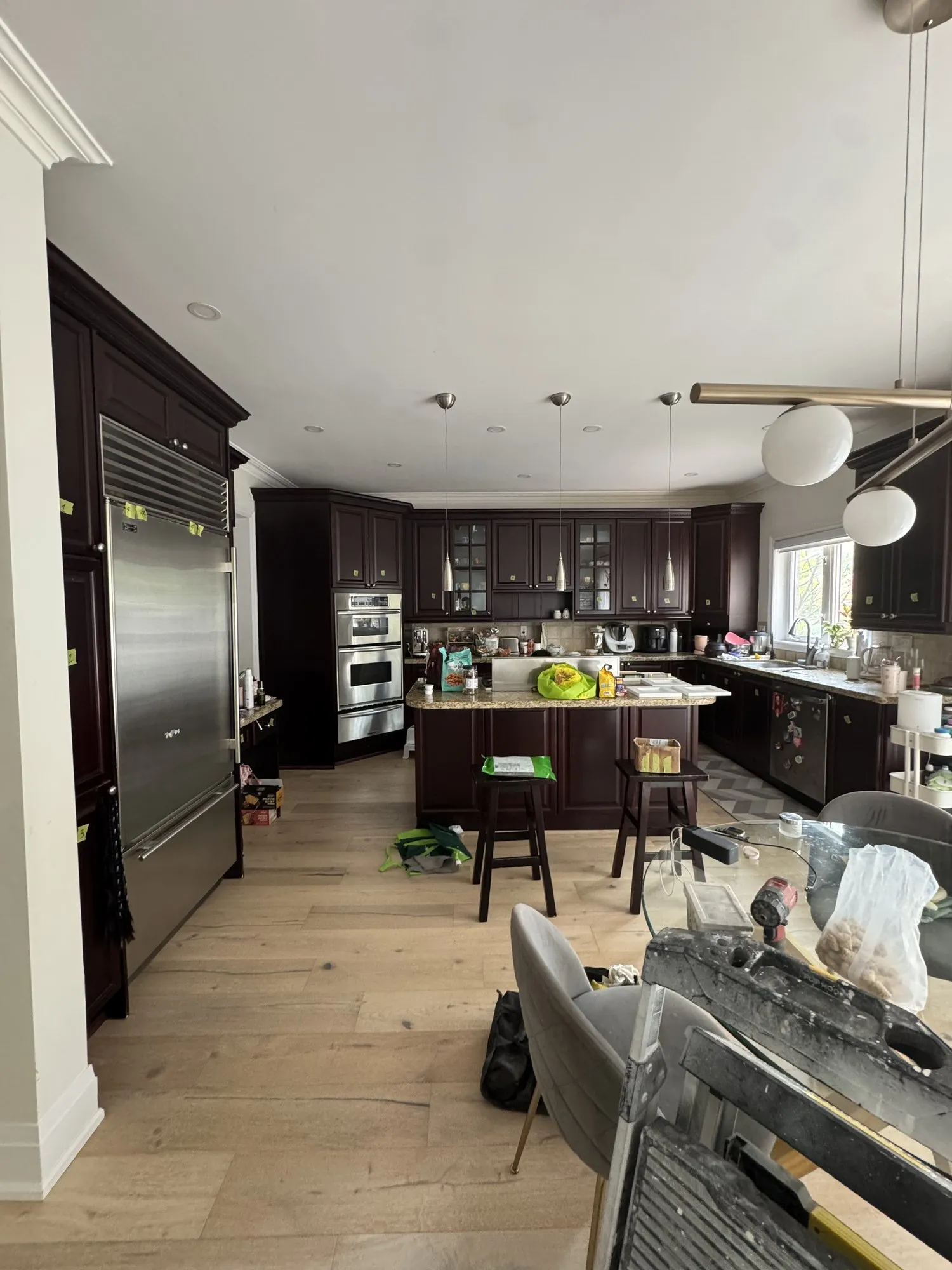 The kitchen before the work, dark espresso cabinetry running the length of the room with a large island and granite counters