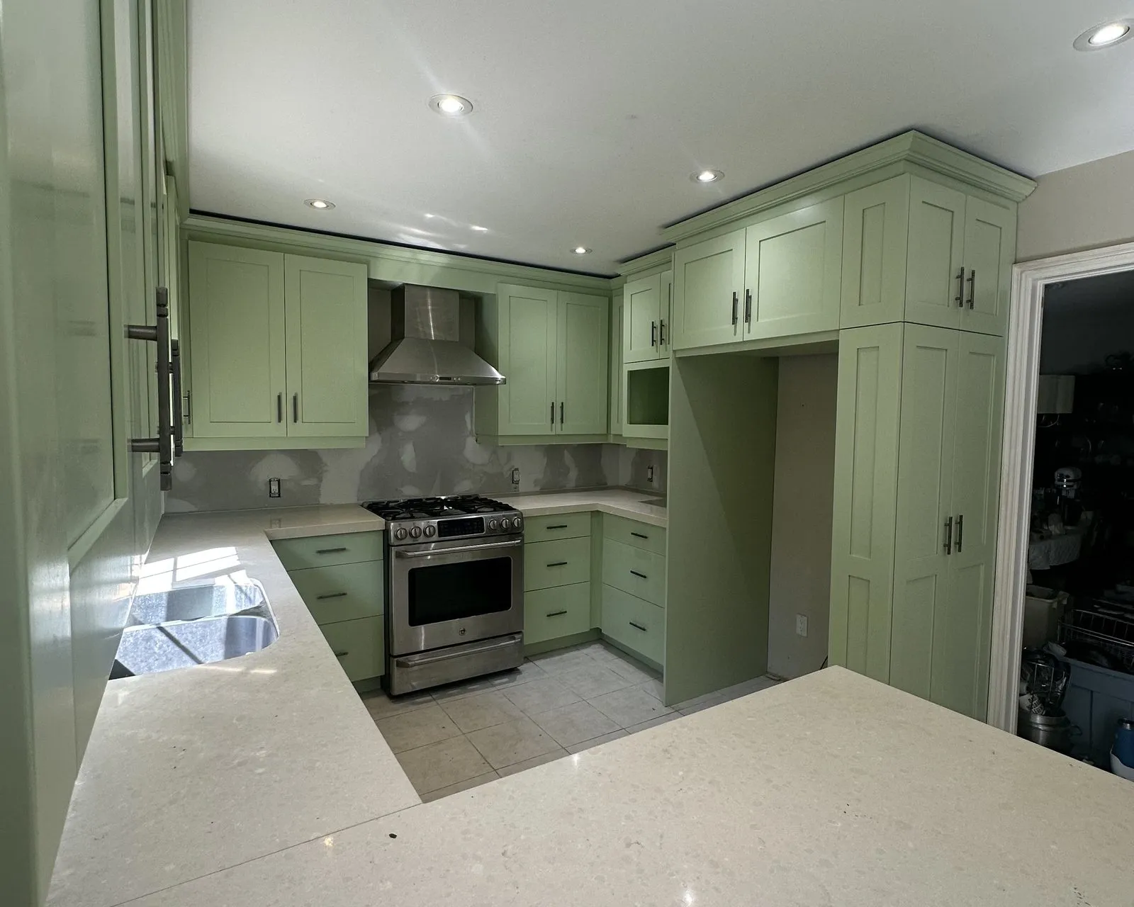After — espresso sprayed sage green, shot before the client's own backsplash went in — Munn's, Oakville