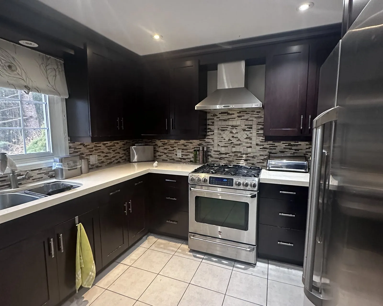 Before — espresso sprayed sage green, shot before the client's own backsplash went in — Munn's, Oakville