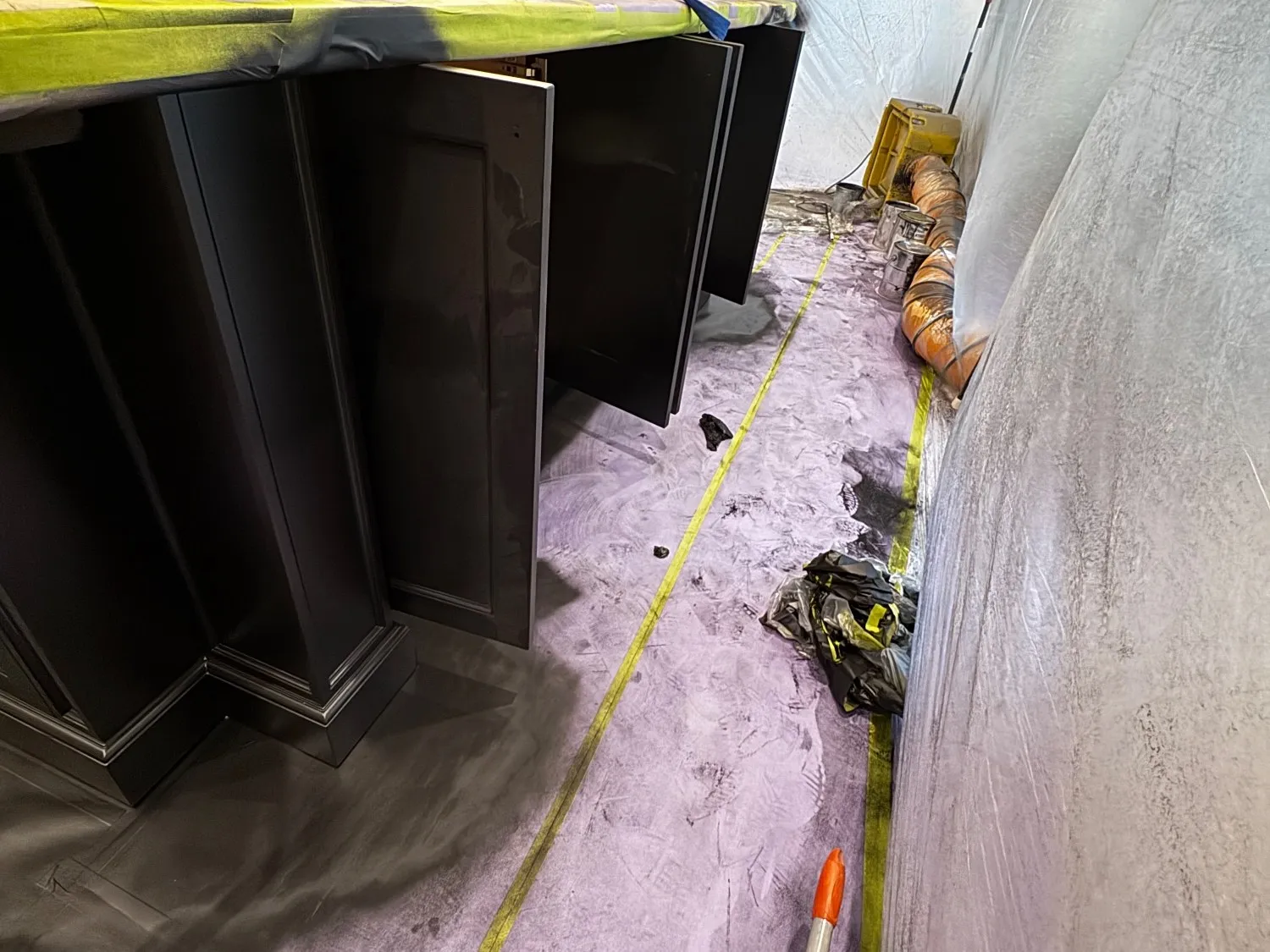 The doors off and standing against the sheeting, the floor covered and the extraction hose run in