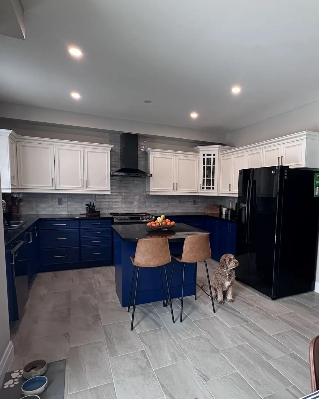 An Oakville kitchen sprayed two-tone — cream uppers above navy lowers and a matching island