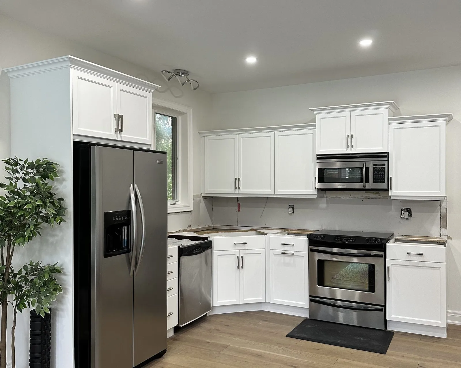 After — dark cherry sprayed white, new handles, counters and backsplash by others in West Oakville, Oakville