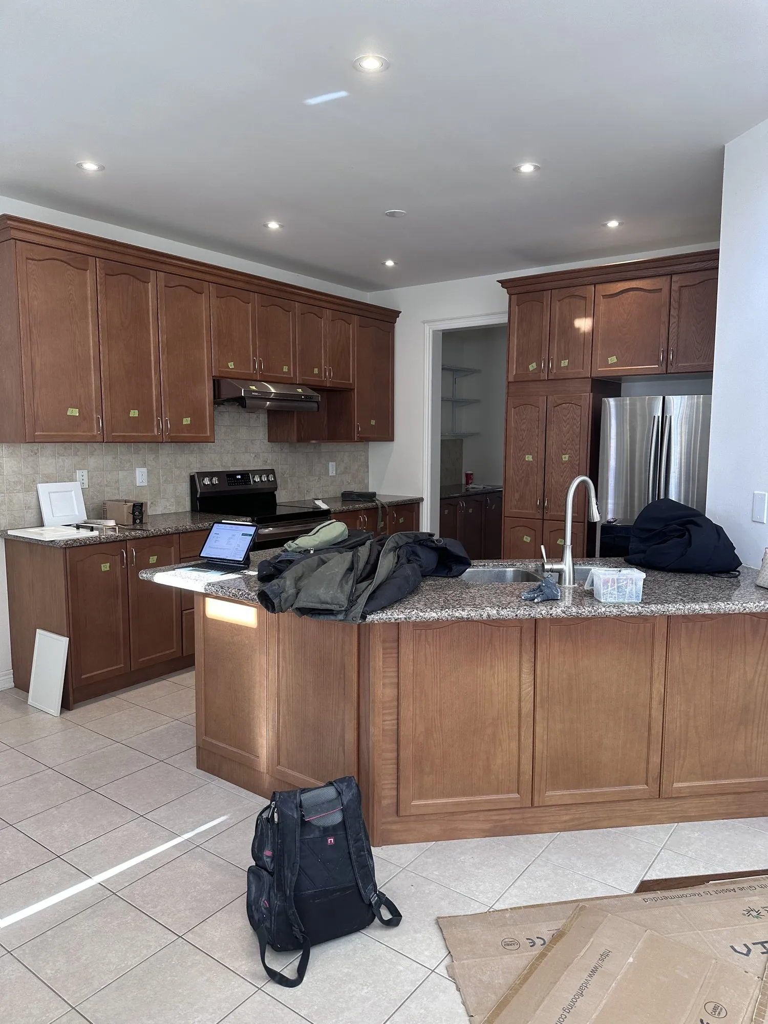 Before — cherry-stained cabinets sprayed white, 32 new handles, granite kept — Glenorchy, Oakville