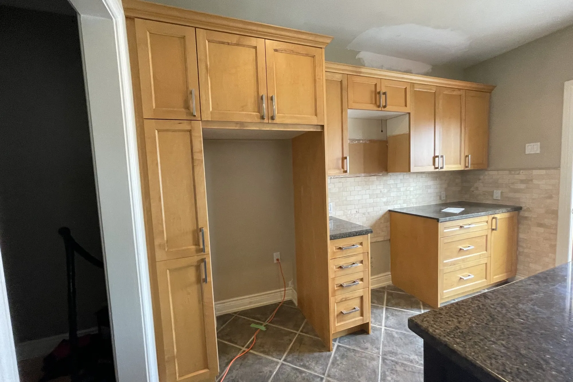 A Joshua Creek kitchen in Oakville after refinishing — maple cabinetry kept and recoated rather than replaced