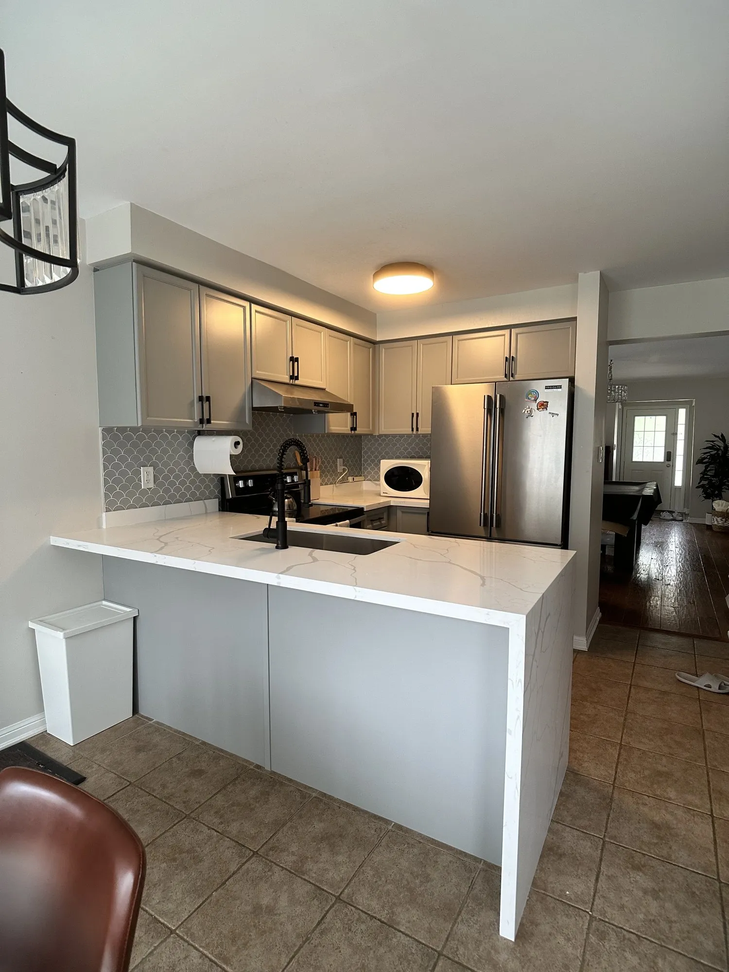The kitchen photographed three days later with new white stone counters fitted, the grey cabinetry unchanged